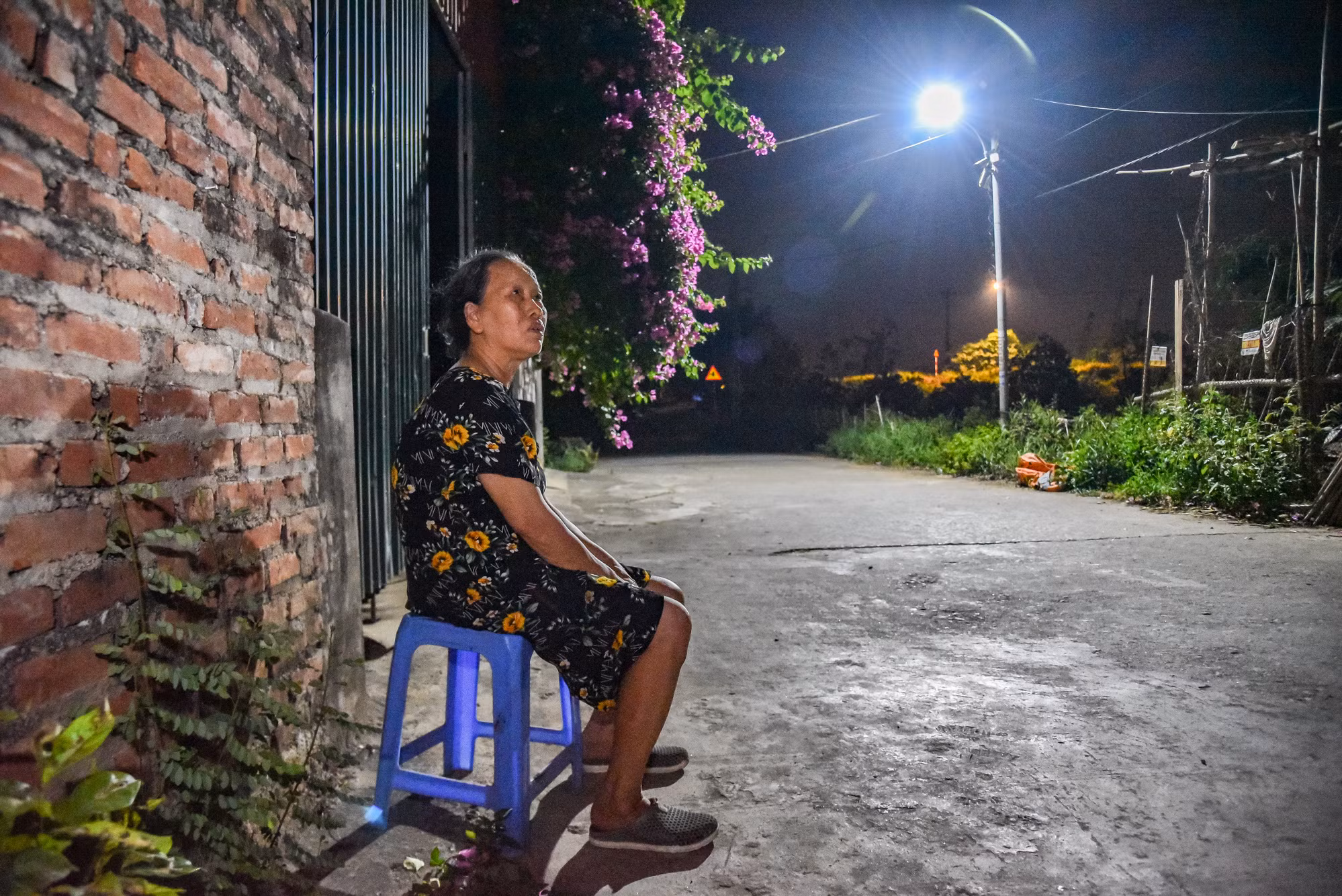 Một số người dân đã đem ghế ra ngoài ngồi để tận dụng ánh sáng của đèn đường.
