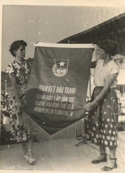Raymonde Dien (trái) tại Đại hội Thanh niên ở Bucharest, Romania, năm 1953. Trong tay bà đang cầm khẩu hiệu của phái đoàn Việt Nam tham dự hội nghị trao tặng. (Ảnh: Robert Aimé) Raymonde Dien (trái) tại Đại hội Thanh niên ở Bucharest, Romania, năm 1953. Trong tay bà đang cầm khẩu hiệu của phái đoàn Việt Nam tham dự hội nghị trao tặng. (Ảnh: Robert Aimé)