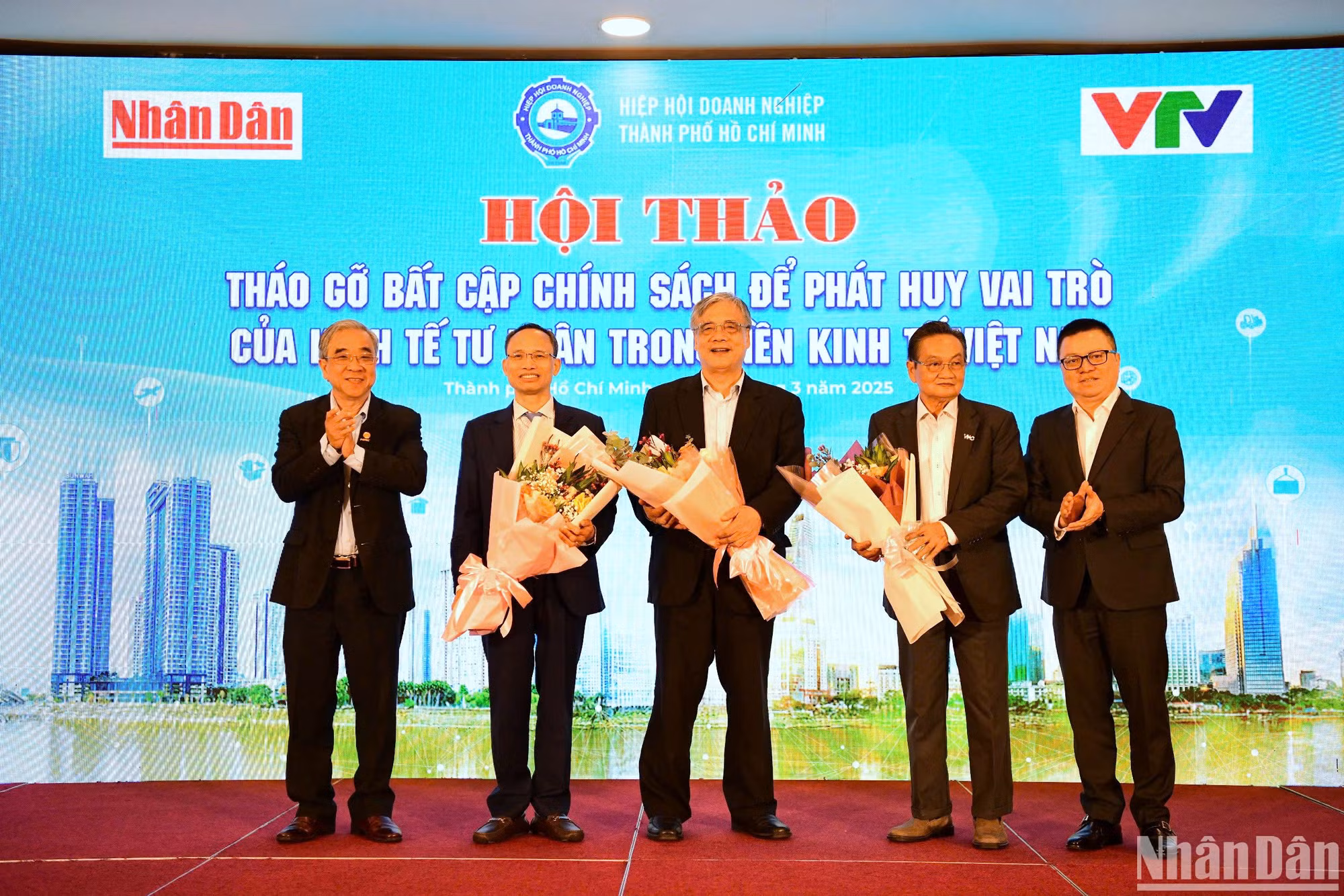 Tổng Biên tập Báo Nhân Dân Lê Quốc Minh và Chủ tịch Hiệp hội Doanh nghiệp Thành phố Hồ Chí Minh Nguyễn Ngọc Hòa tặng hoa cảm ơn các chuyên gia tham dự hội thảo. (Ảnh: THẾ DƯƠNG)