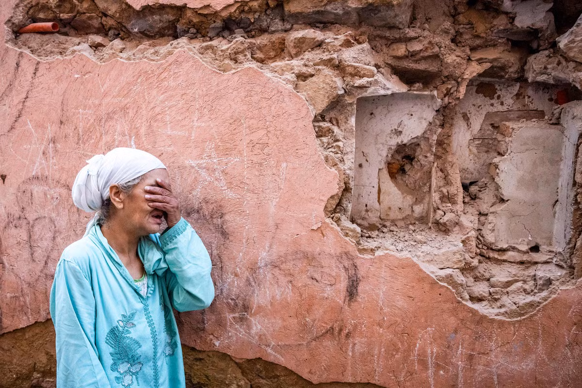 Người phụ nữ đứng trước ngôi nhà của mình bị trận động đất tàn phá.(Ảnh: AFP/Getty Images/CNN)