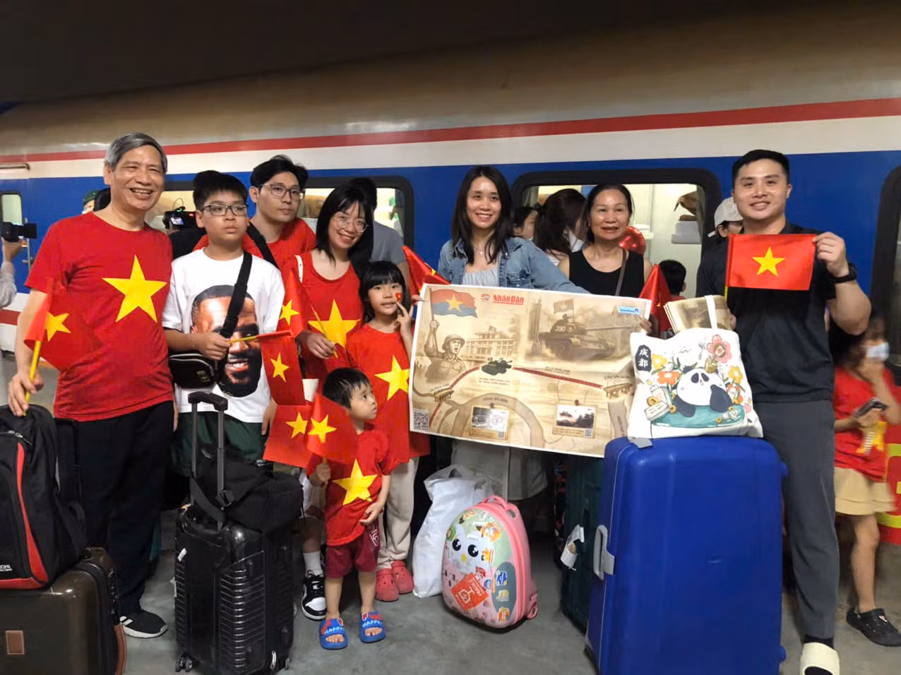 Ông Đinh Văn Là (bìa trái), quận Hai Bà Trưng, Hà Nội, cùng đại gia đình trên tay phụ san đặc biệt của Báo Nhân Dân trước giờ lên tàu. (Ảnh: TUẤN ANH) Ông Đinh Văn Là (bìa trái), quận Hai Bà Trưng, Hà Nội, cùng đại gia đình trên tay phụ san đặc biệt của Báo Nhân Dân trước giờ lên tàu. (Ảnh: TUẤN ANH)