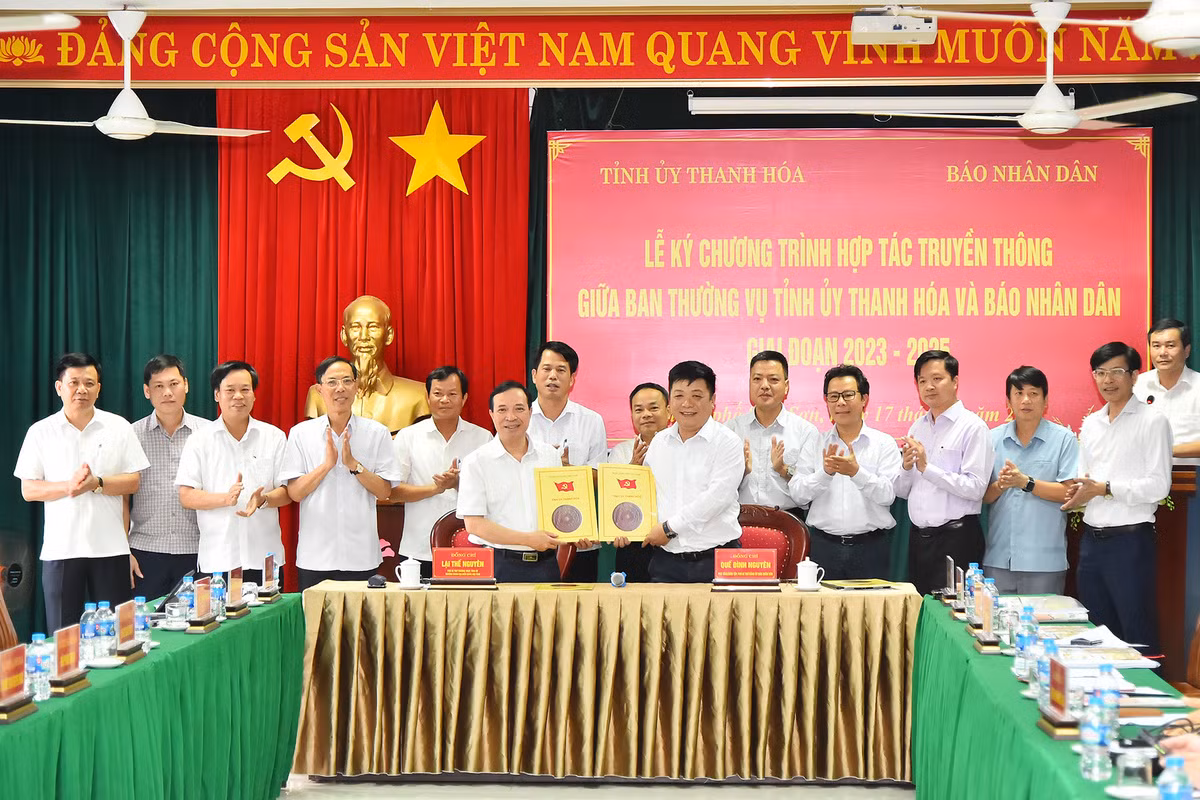 Phó Tổng Biên tập Báo Nhân Dân Quế Đình Nguyên và Phó Bí thư Thường trực Tỉnh ủy Thanh Hoá Lại Thế Nguyên trao nhau bản thỏa thuận hợp tác truyền thông giữa 2 cơ quan trước sự chứng kiến của lãnh đạo 2 đơn vị.