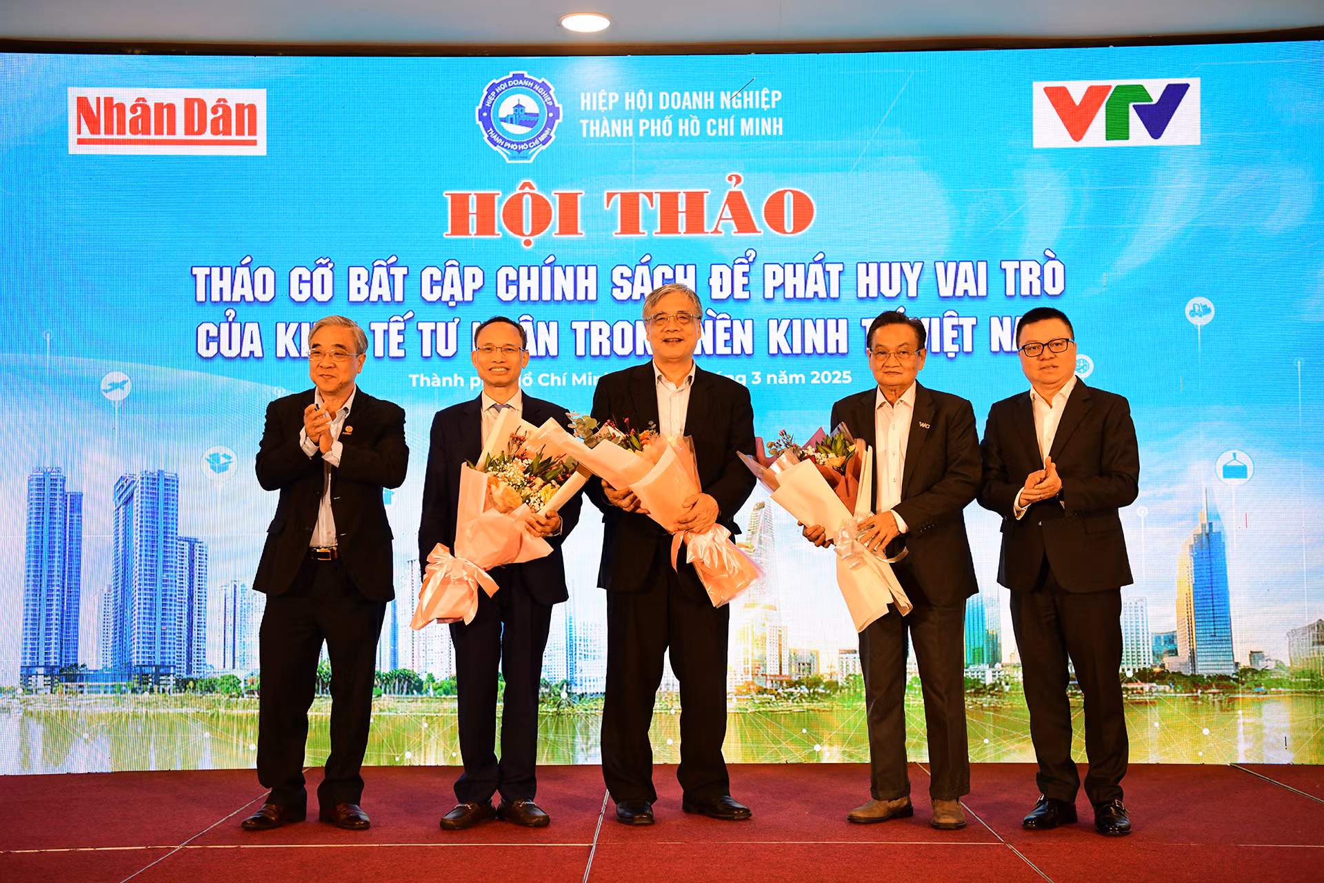 Ban Tổ chức tặng hoa kỷ niệm tới các chuyên gia kinh tế tham dự hội thảo.