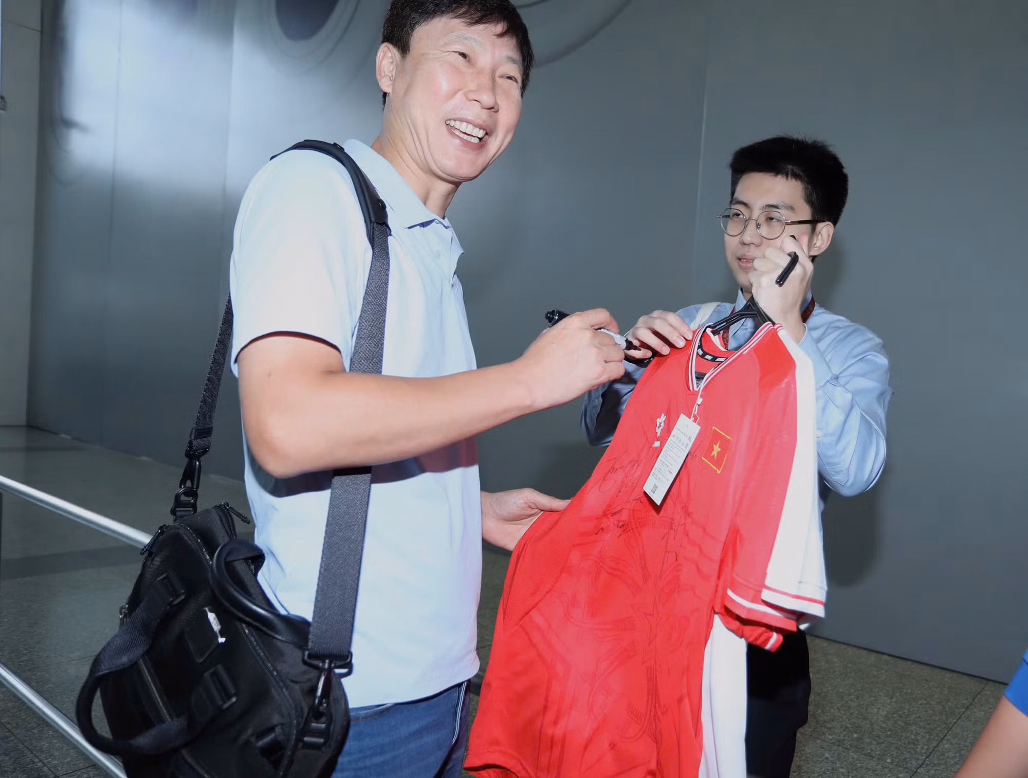 Thầy Kim Sang-sik vui vẻ ký áo tặng người hâm mộ.