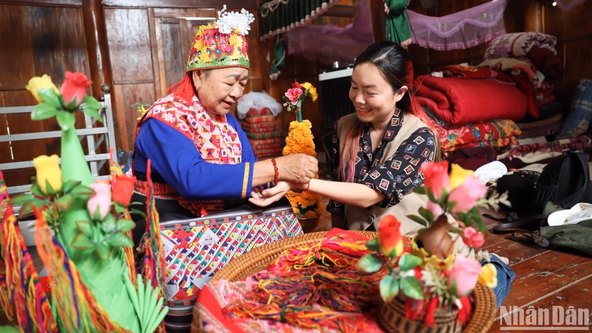 Nghệ nhân người Lào ở xã Núa Ngam, huyện Điện Biên thực hiện nghi thức văn hóa buộc chỉ cổ tay cầu may cho du khách.