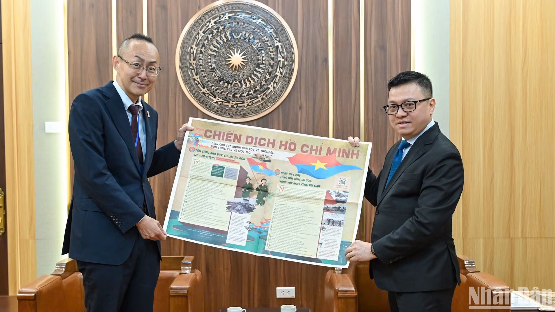 Tổng Biên tập Lê Quốc Minh giới thiệu phụ san đặc biệt của Báo Nhân Dân kỷ niệm 50 năm Ngày Giải phóng miền nam, Thống nhất đất nước tới Trưởng Đại diện JICA tại Việt Nam, ông Kobayashi Yosuke. (Ảnh: BÙI GIANG)