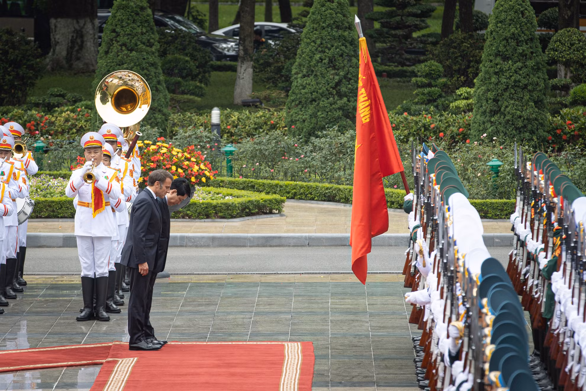 Chủ tịch nước Lương Cường và Tổng thống Pháp Emmanuel Macron cúi chào Quân kỳ Quyết thắng.