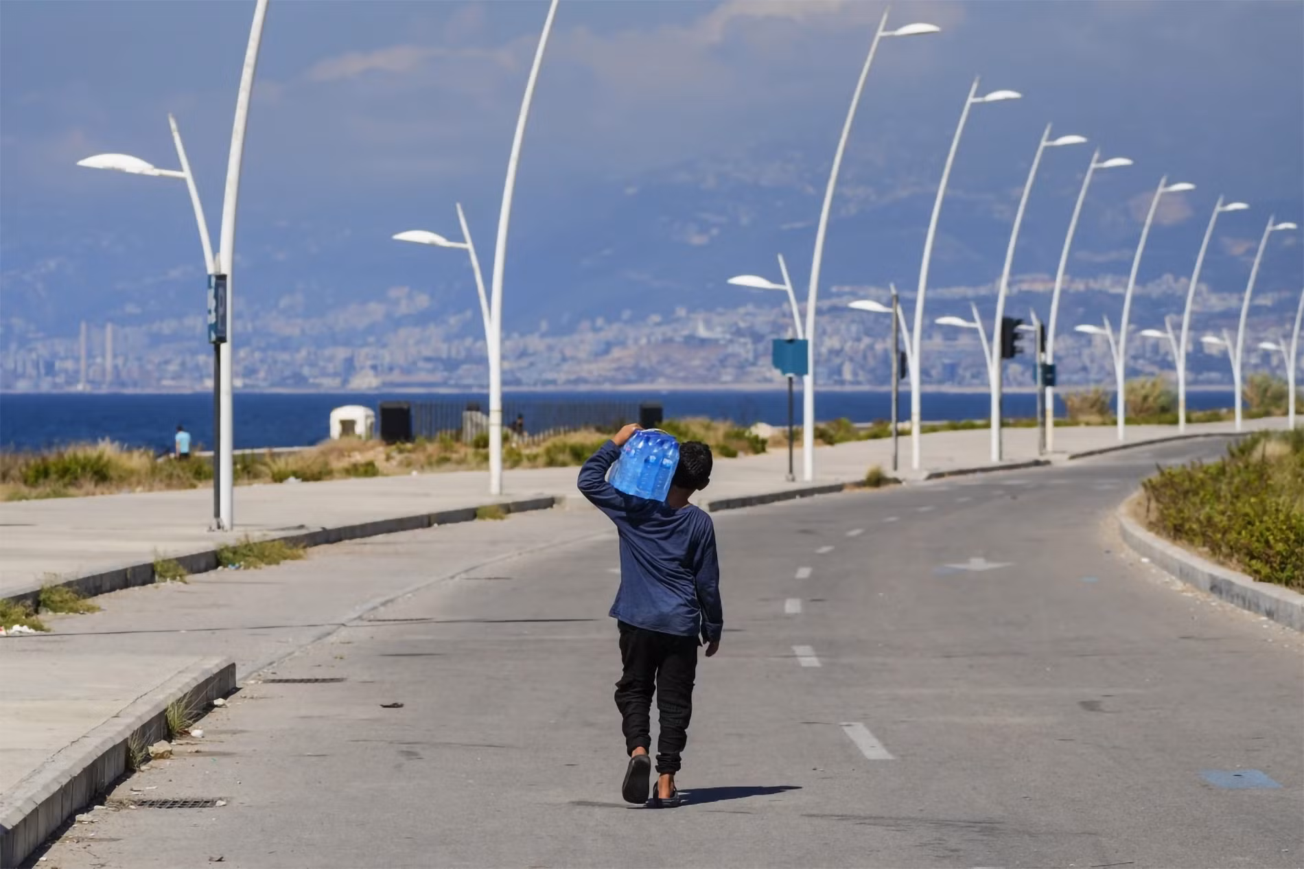 Chú bé bán nước dạo trên con đường dọc biển Địa Trung Hải tại Beirut, Lebanon, ngày 20/7/2023. (Ảnh: AP)