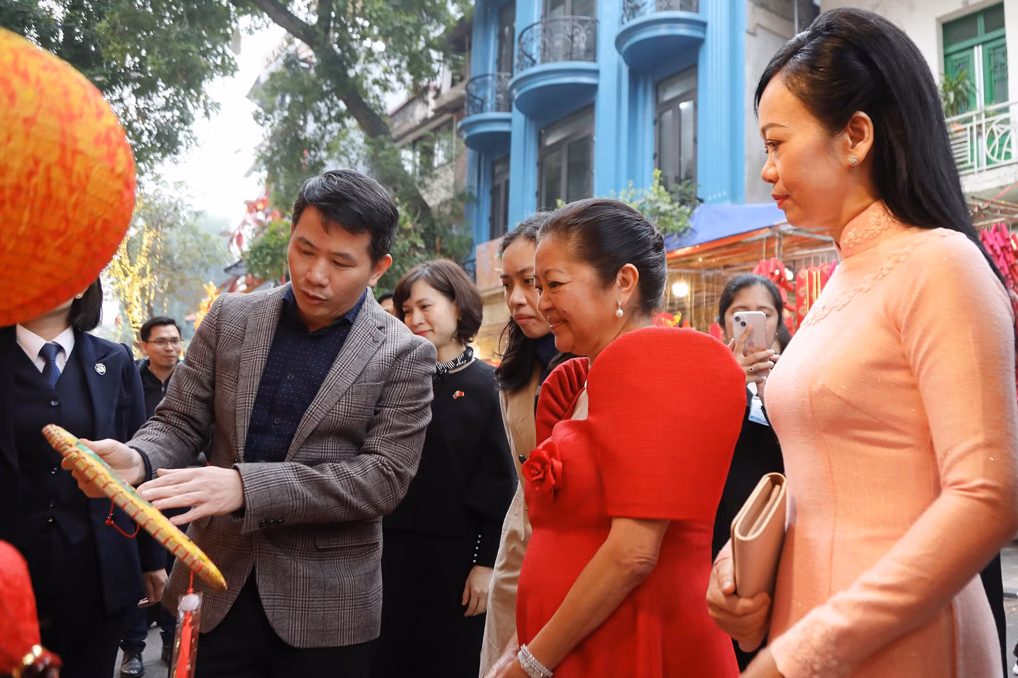 Hai Phu nhân nghe giới thiệu về những vật phẩm trang trí ngày Tết được bày bán tại phố Hàng Mã.