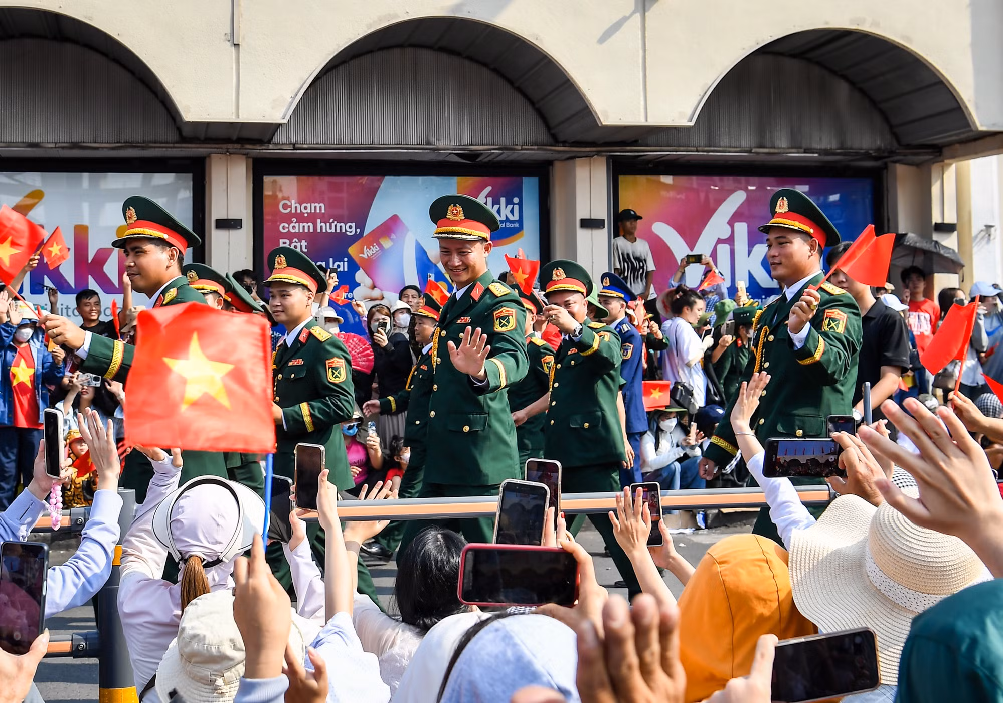 Các chiến sĩ vừa đi, vừa mỉm cười, gật đầu, vẫy tay chào người dân hai bên đường. Không ít người tranh thủ chụp ảnh, quay clip ghi lại khoảnh khắc hiếm có này.