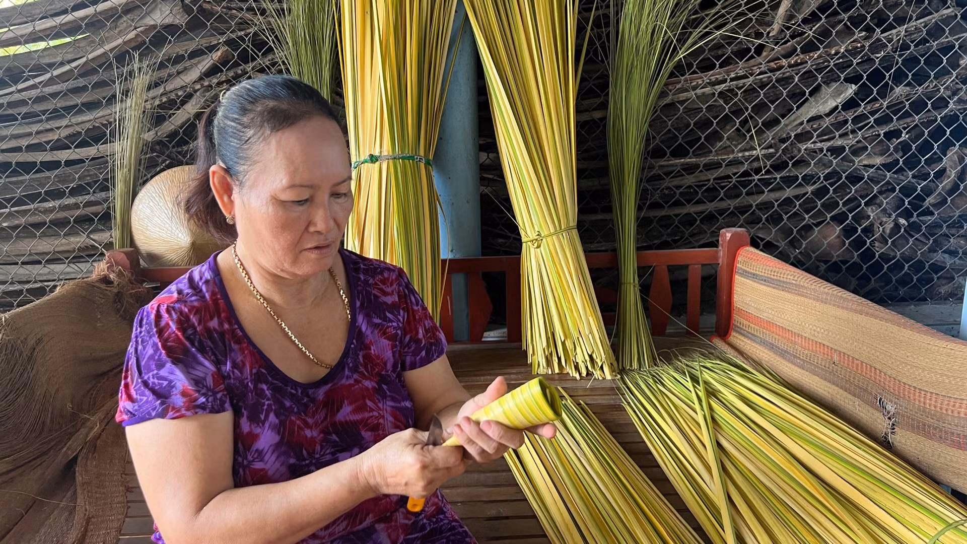 Bà Đoàn Thị Bé tạo khung từ lá dừa nước non để gói bánh Bà Đoàn Thị Bé tạo khung từ lá dừa nước non để gói bánh