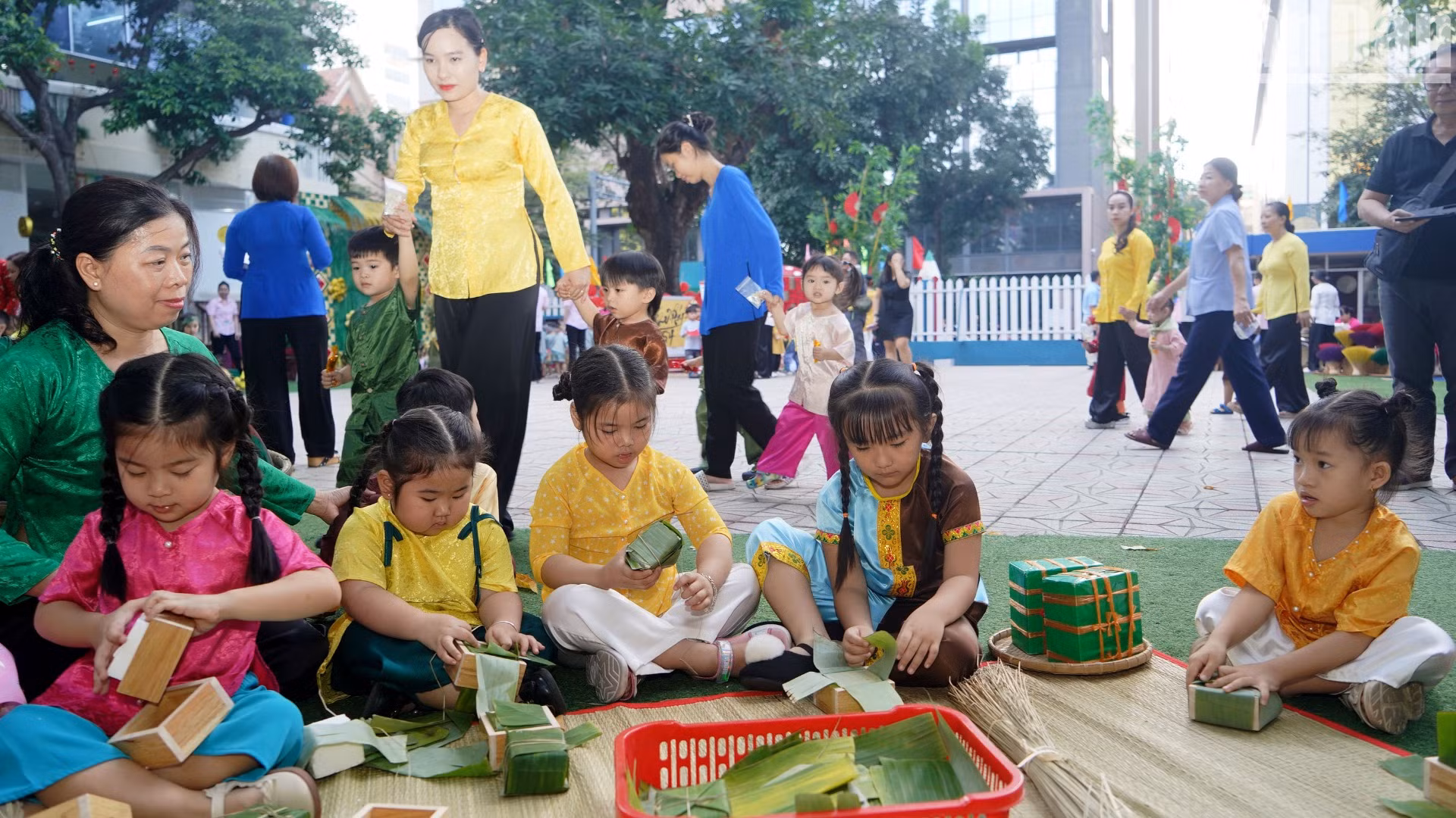 Các em nhỏ chăm chú quan sát, lắng nghe và học theo cô giáo gói bánh.