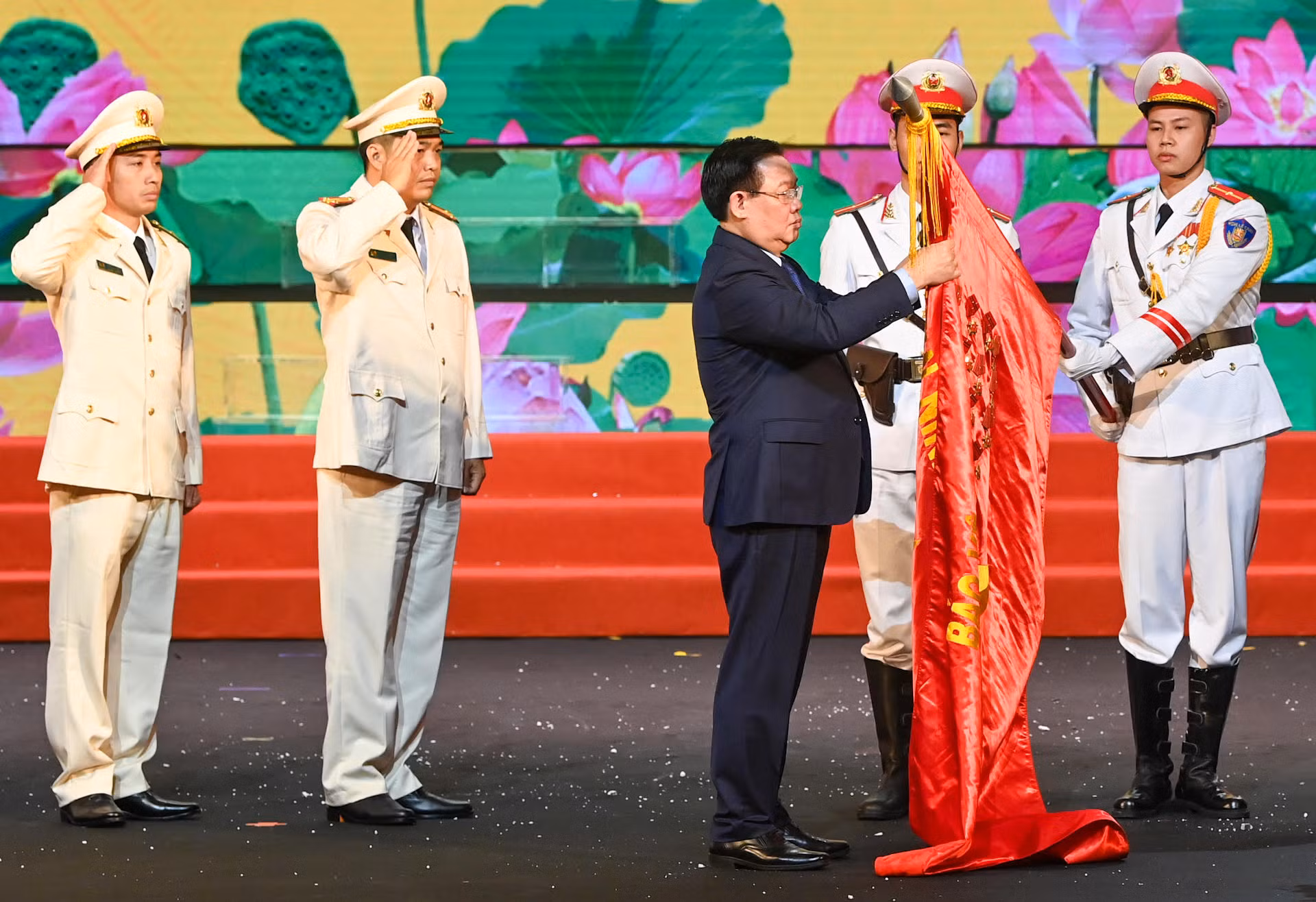 Chủ tịch Quốc hội Vương Đình Huệ gắn Huân chương lên lá cờ truyền thống của lực lượng Cảnh sát phòng cháy, chữa cháy và cứu nạn, cứu hộ.