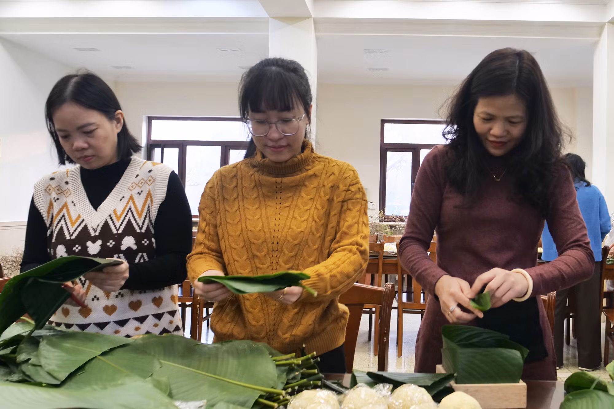 Các chị em công đoàn viên cắt, xếp lá dong. Các chị em công đoàn viên cắt, xếp lá dong.
