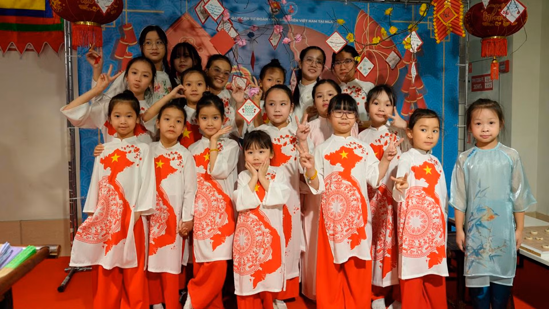 Các em nhỏ trong tà áo dài in hình Tổ quốc trải nghiệm Ngày Tết cổ truyền. Các em nhỏ trong tà áo dài in hình Tổ quốc trải nghiệm Ngày Tết cổ truyền.