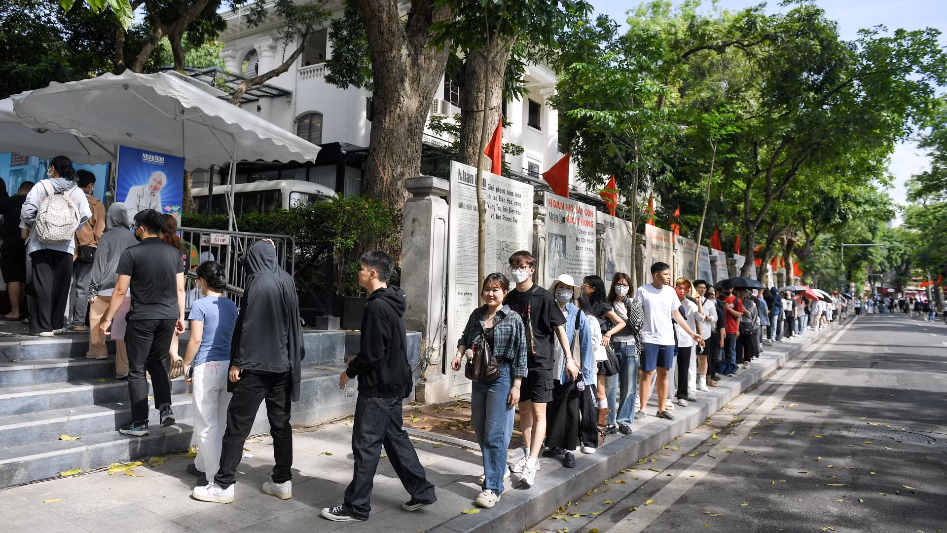 Hàng dài người dân, du khách tại khu vực phố đi bộ Hồ Hoàn Kiếm đợi nhận phụ san đặc biệt kỷ niệm 135 năm Ngày sinh Chủ tịch Hồ Chí Minh.
