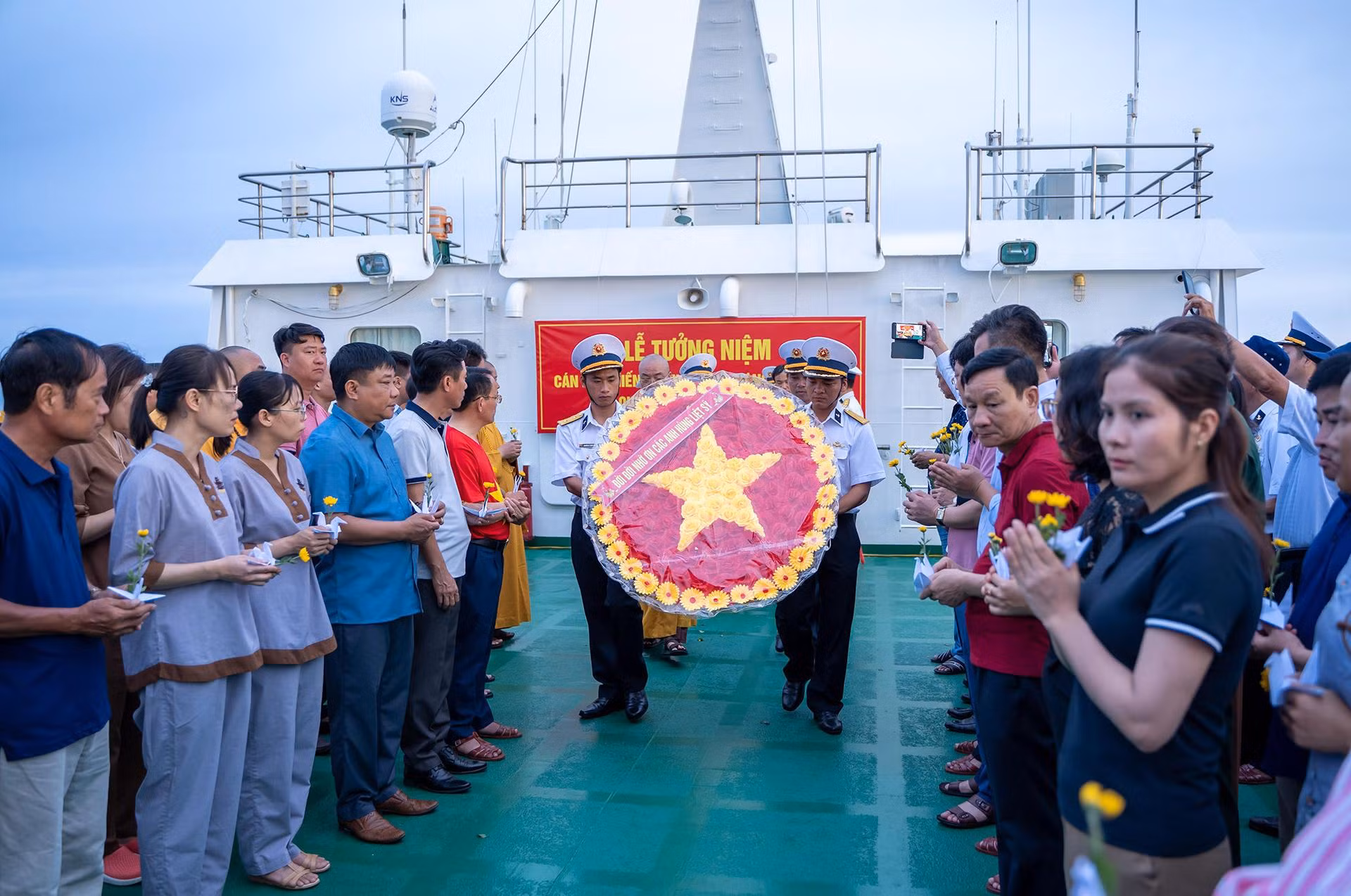 Sau lễ mặc niệm, vòng hoa “Đời đời nhớ ơn các anh hùng, liệt sĩ” được các chiến sĩ Hải quân làm lễ rước trang trọng giữa hai hàng đại biểu.
