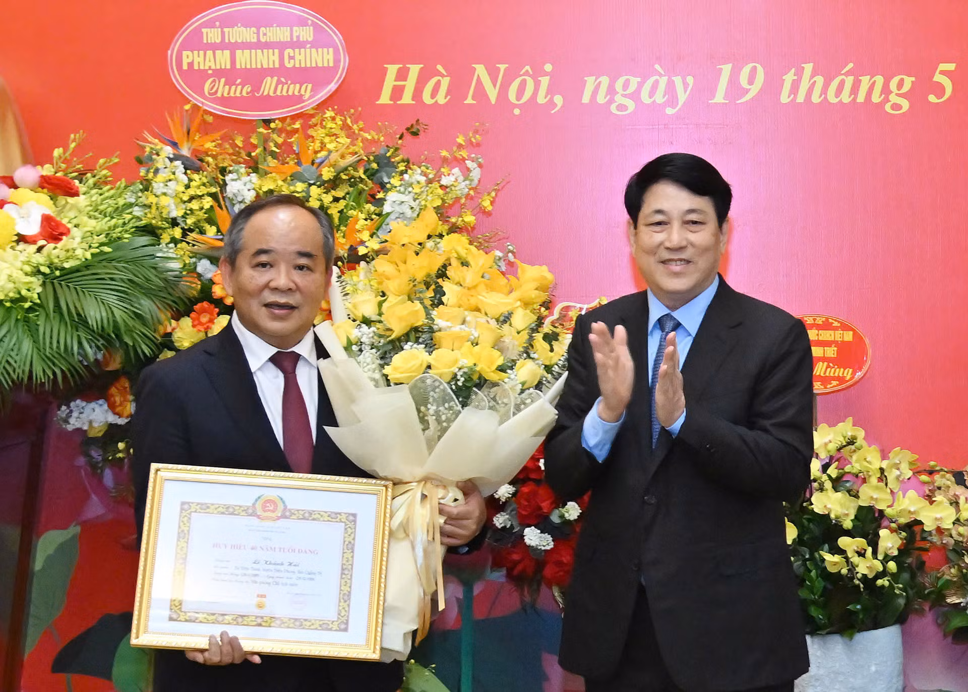 Chủ tịch nước Lương Cường trao Huy hiệu 40 năm tuổi Đảng, tặng hoa chúc mừng Chủ nhiệm Văn phòng Chủ tịch nước Lê Khánh Hải.