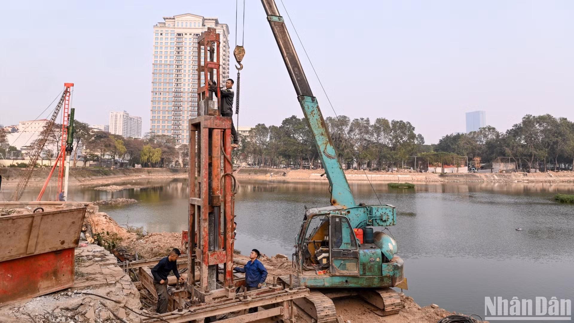 Đơn vị thi công đang ép cọc bê-tông để xây trụ cầu đi bộ trong công viên.