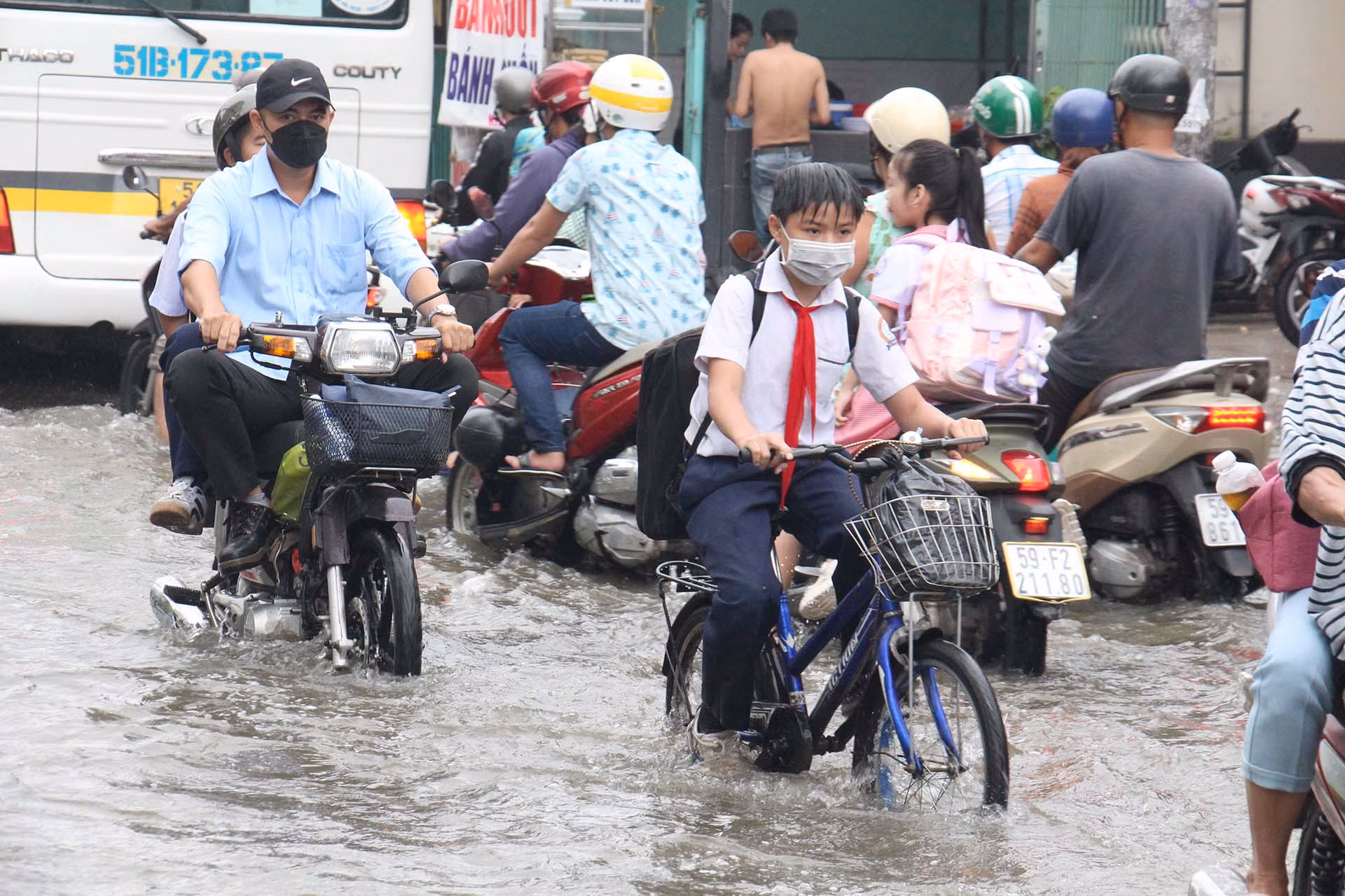 Khoảng 6 giờ, nước từ các con sông ồ ạt chảy vào đường Lê Văn Lương khiến việc đi lại của các em học sinh, người dân khá vất vả.