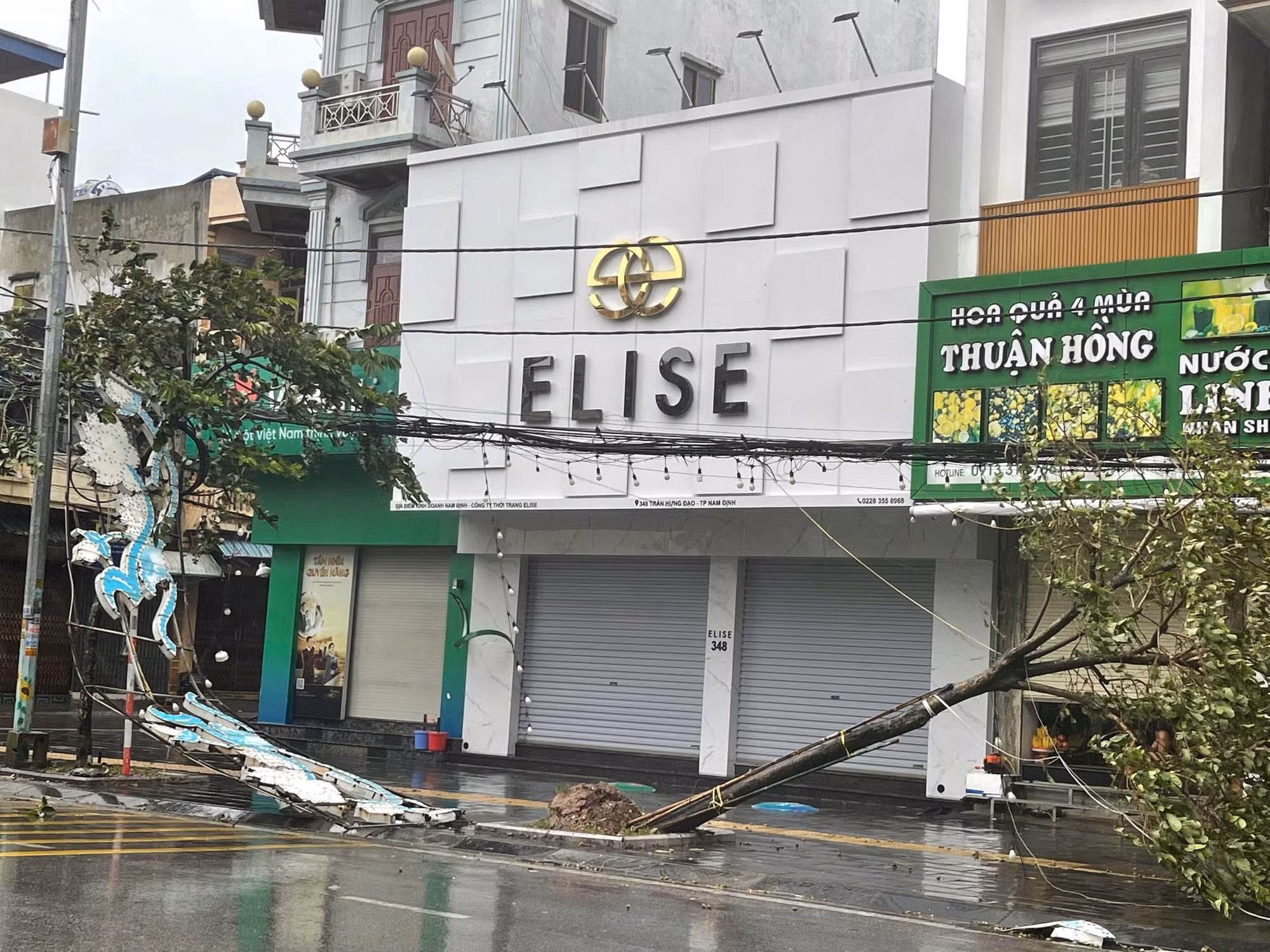 Nhiều biển quảng cáo bị gió quật đổ, cây xanh đổ ngổn ngang, kéo theo cả dây điện và đường dây thông tin ở thành phố Nam Định.