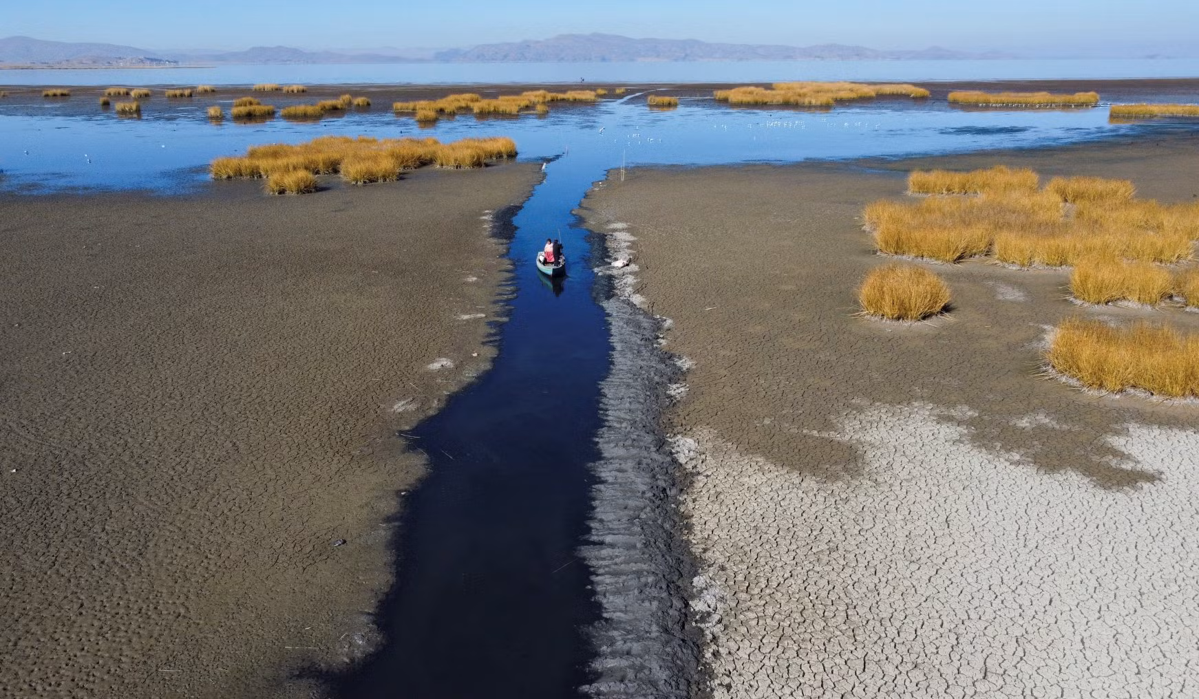 Hồ nước ngọt Titicaca, nằm trong dãy núi Andes ở biên giới Bolivia và Peru hiện có mực nước thấp nhất từ trước đến nay do đợt nắng nóng vừa qua. Một con thuyền đi qua con nước hẹp của hồ vào ngày 3/8. Ảnh: Reuters.