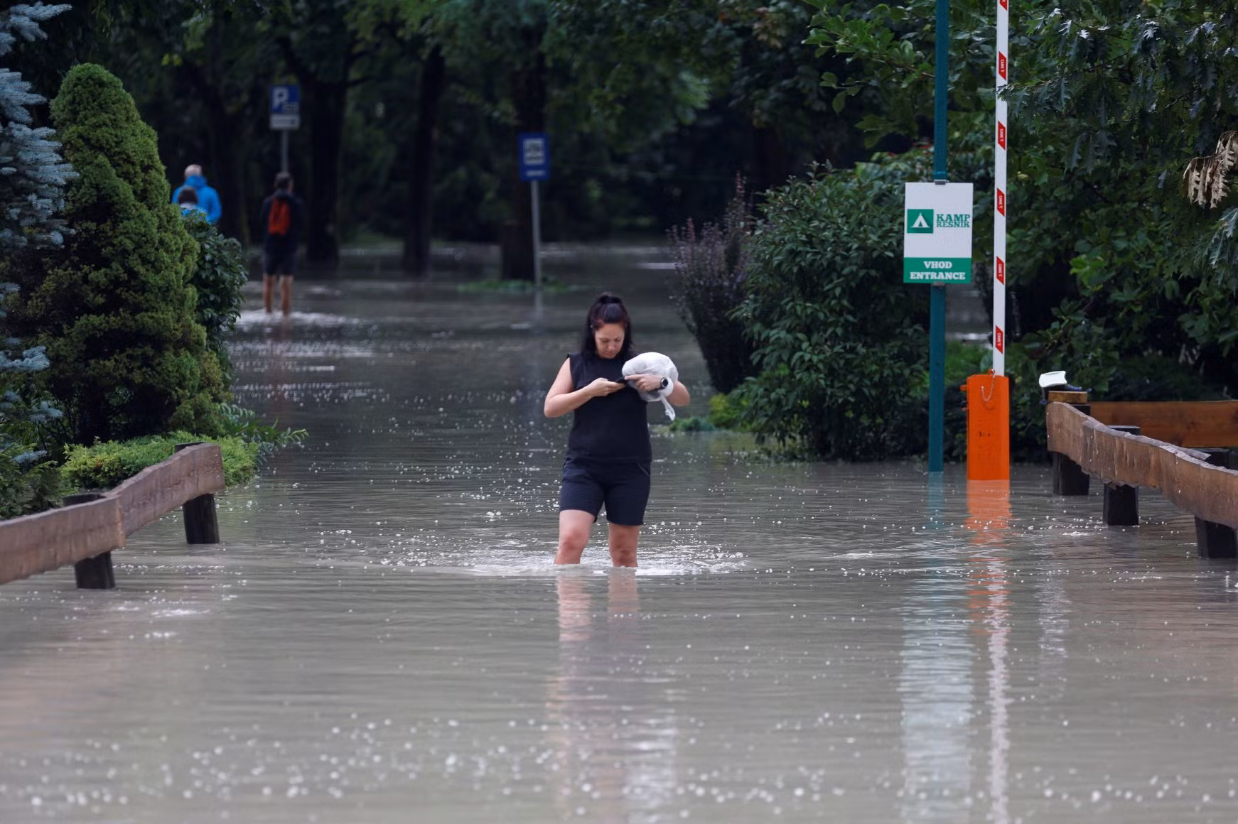 Một người phụ nữ lội nước trong trận lũ lụt ở Kamnik, Slovenia ngày 4/8. Ảnh: Reuters.