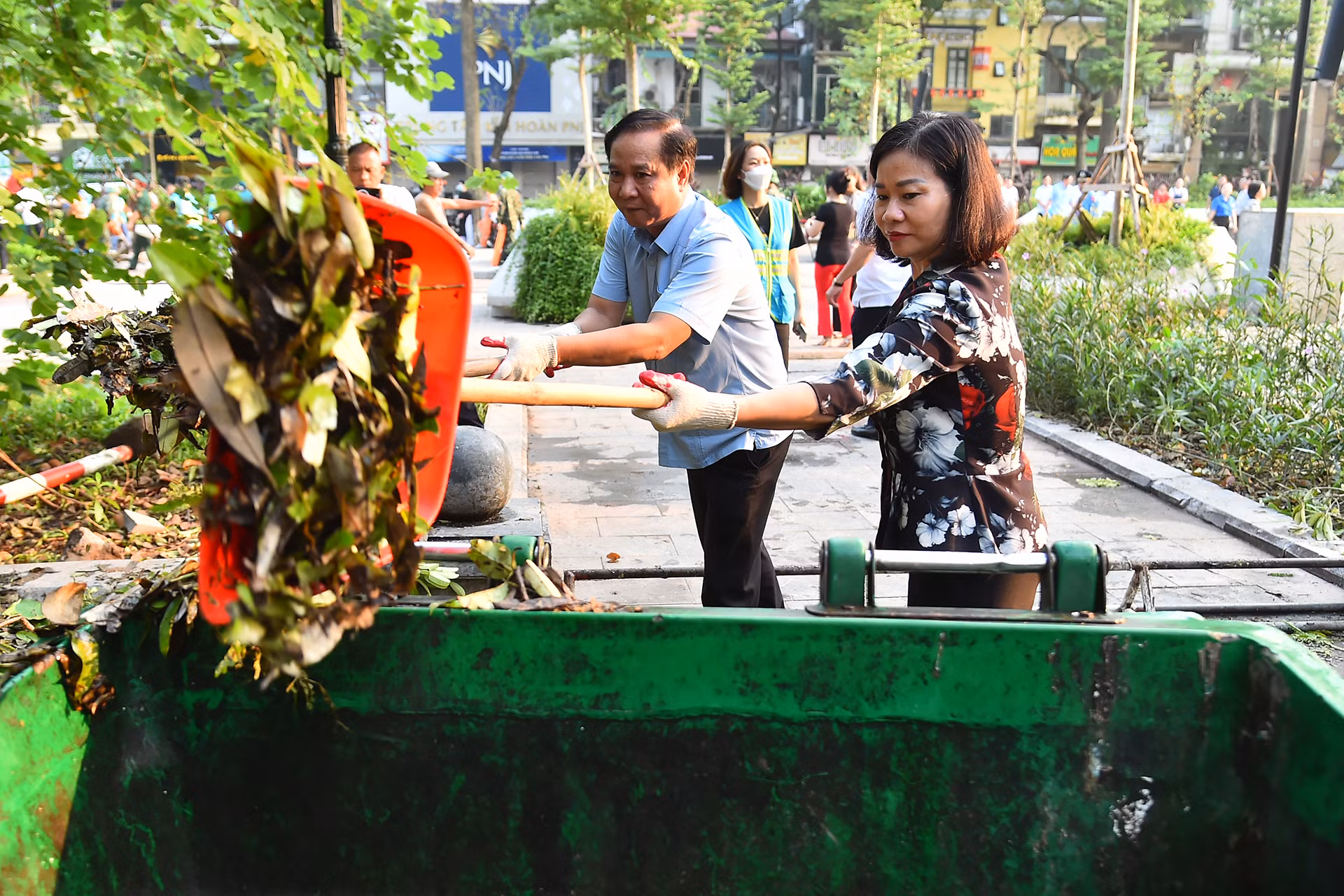 Phó Bí thư Thường trực Thành ủy Hà Nội Nguyễn Thị Tuyến tham gia dọn dẹp vệ sinh môi trường tại Vườn hoa Vạn Xuân.
