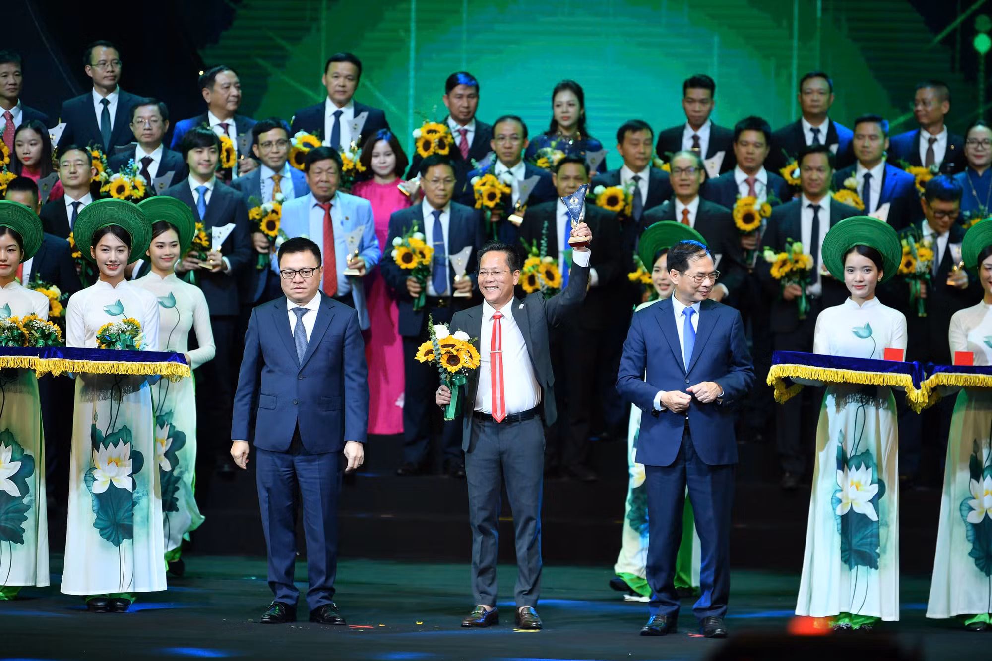Phó Thủ tướng Chính phủ, Bộ trưởng Ngoại giao Bùi Thanh Sơn và Tổng Biên tập Báo Nhân Dân, Chủ tịch Hội Nhà báo Việt Nam Lê Quốc Minh trao biểu trưng và hoa cho đại diện các doanh nghiệp.