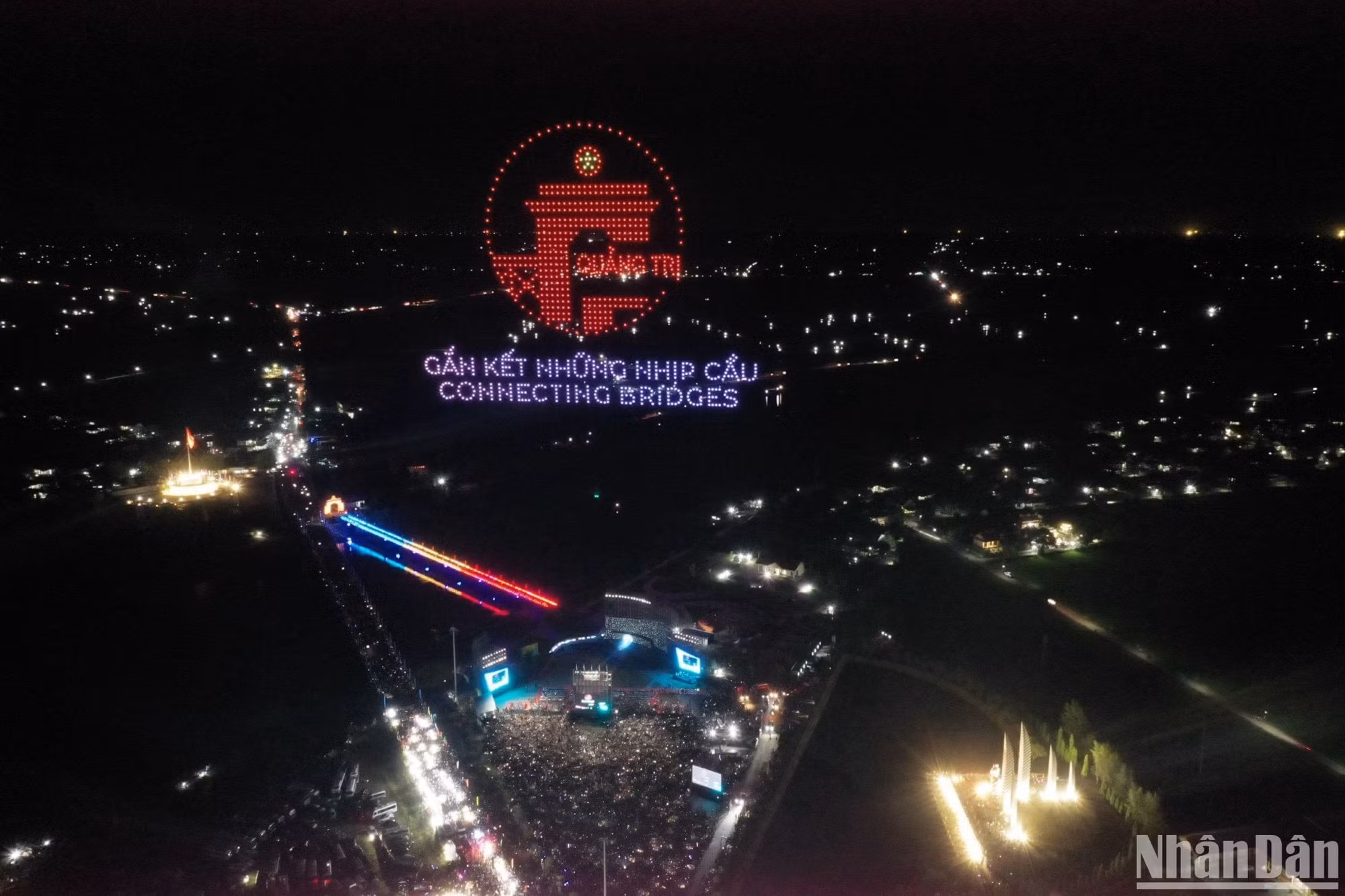 Drone light vẽ biểu tượng logo Quảng Trị và tên chủ đề chương trình "Gắn kết những nhịp cầu - Connecting bridges" trên bầu trời sông Bến Hải.