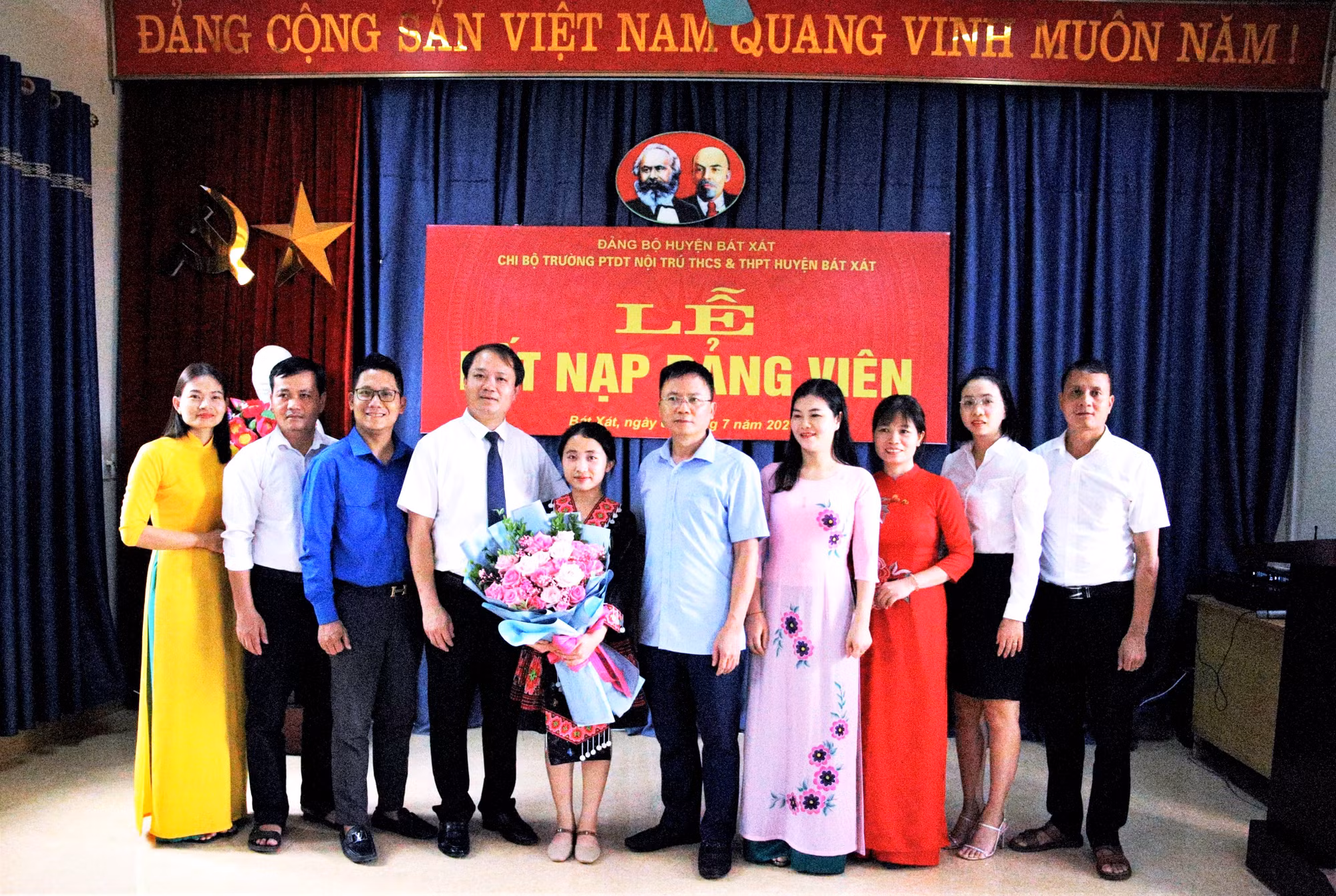 Lãnh đạo Huyện ủy Bát Xát và Trường Phổ thông Dân tộc nội trú THCS và THPT Bát Xát (Lào Cai) tặng hoa chúc mừng đảng viên Vừ Thị Sấy, học sinh lớp 12A của nhà trường. (Ảnh: Quốc Hồng)