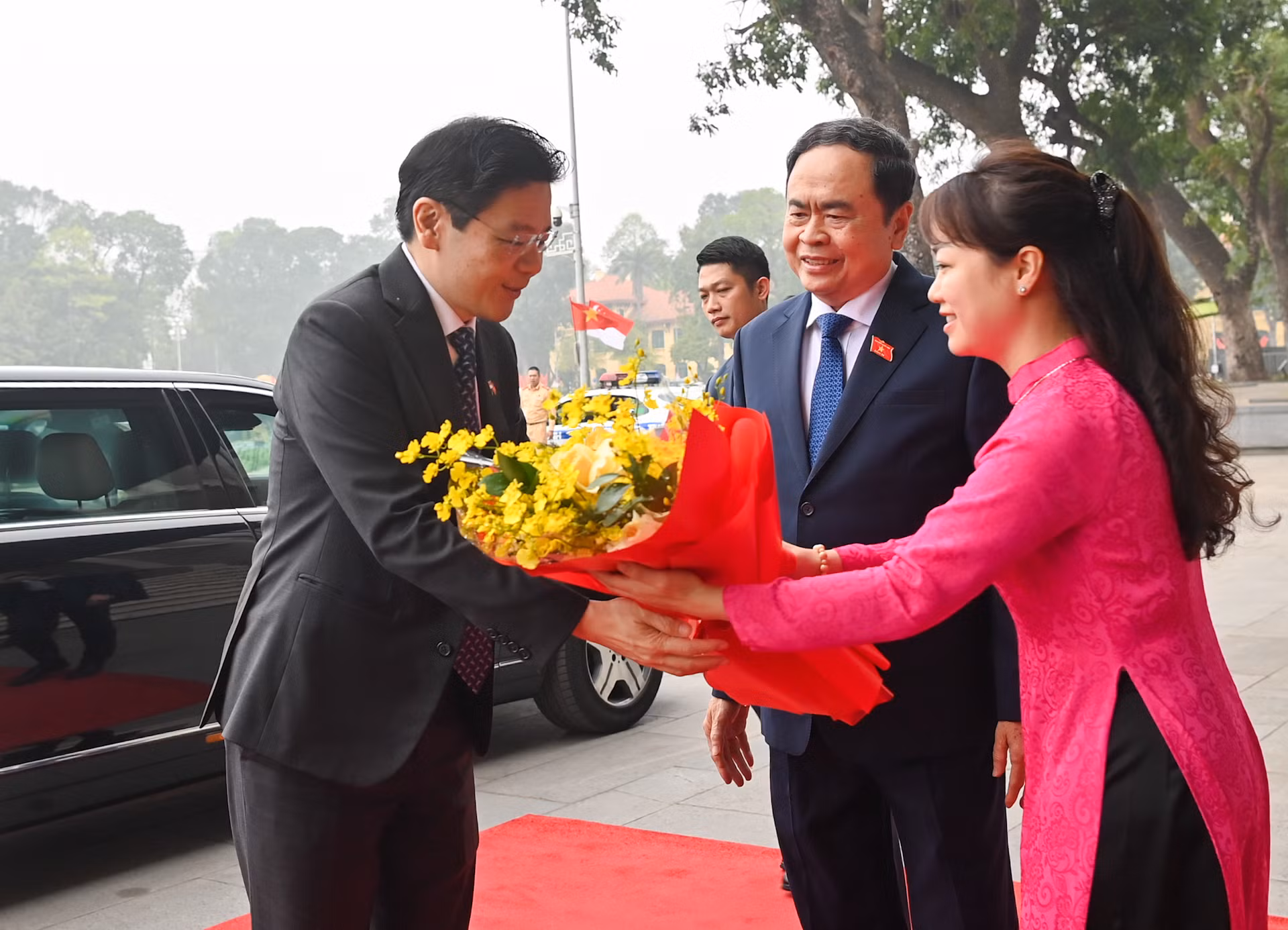 Nhân viên Văn phòng Quốc hội tặng hoa chào mừng Thủ tướng Singapore Lawrence Wong.
