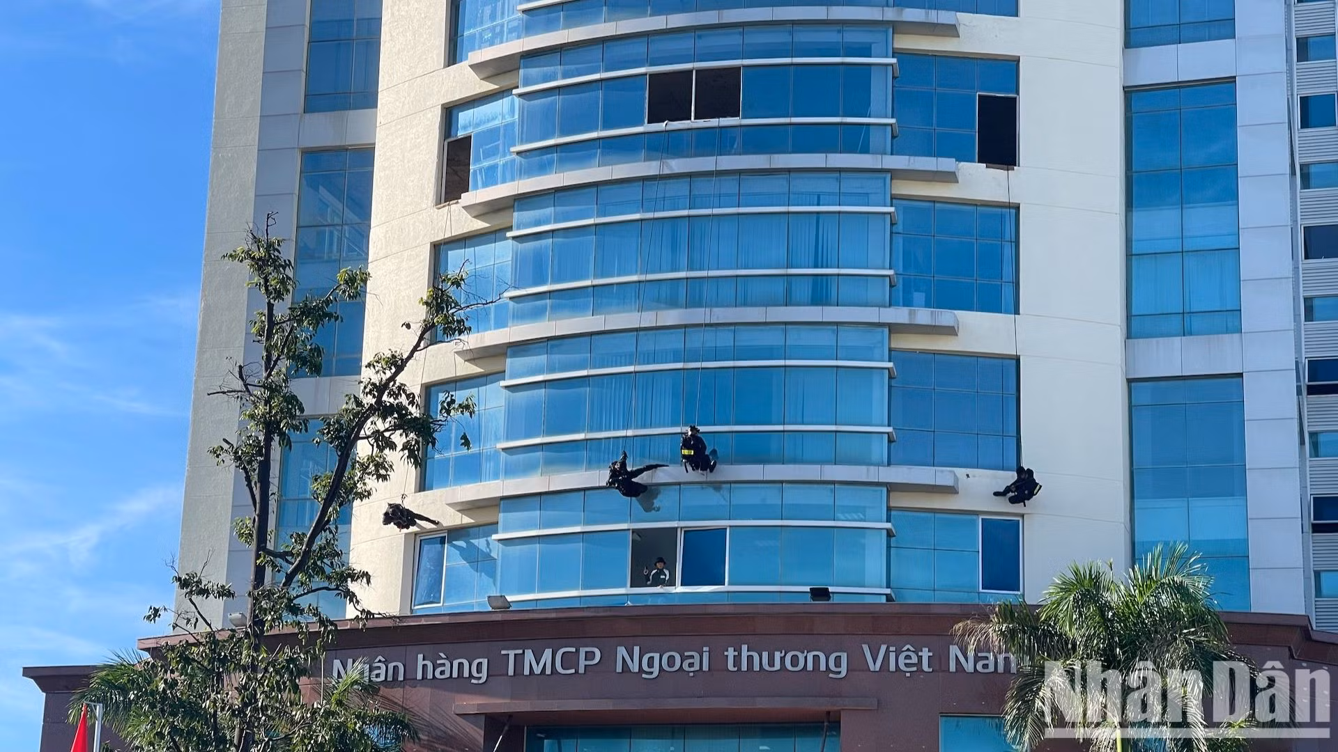 Công an đang đu dây thang xuống để đi vào bên trong tòa nhà. Công an đang đu dây thang xuống để đi vào bên trong tòa nhà.