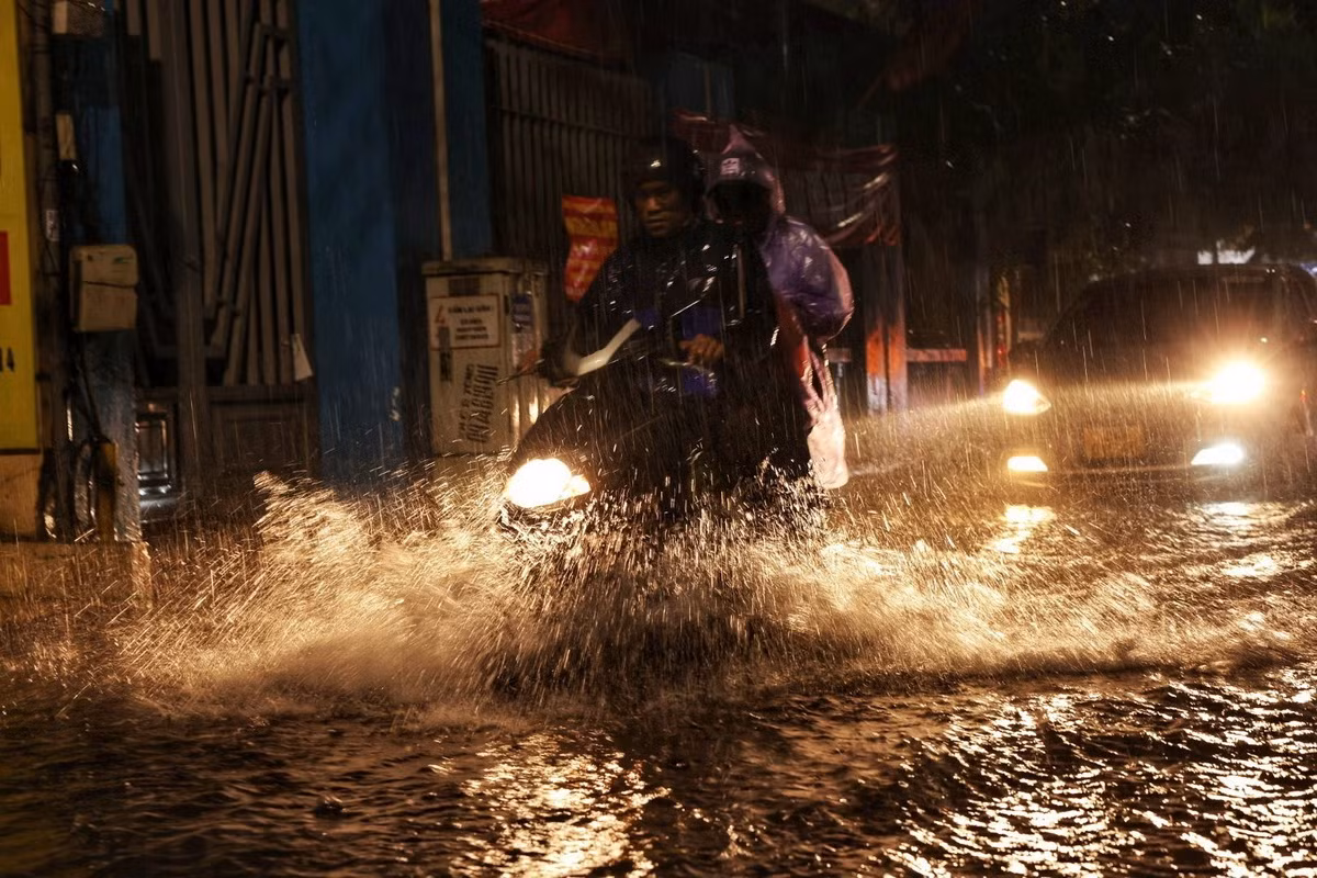 Các phương tiện di chuyển khó khăn khi qua những chỗ bị ngập. (Ảnh: Tuấn Anh/TTXVN)
