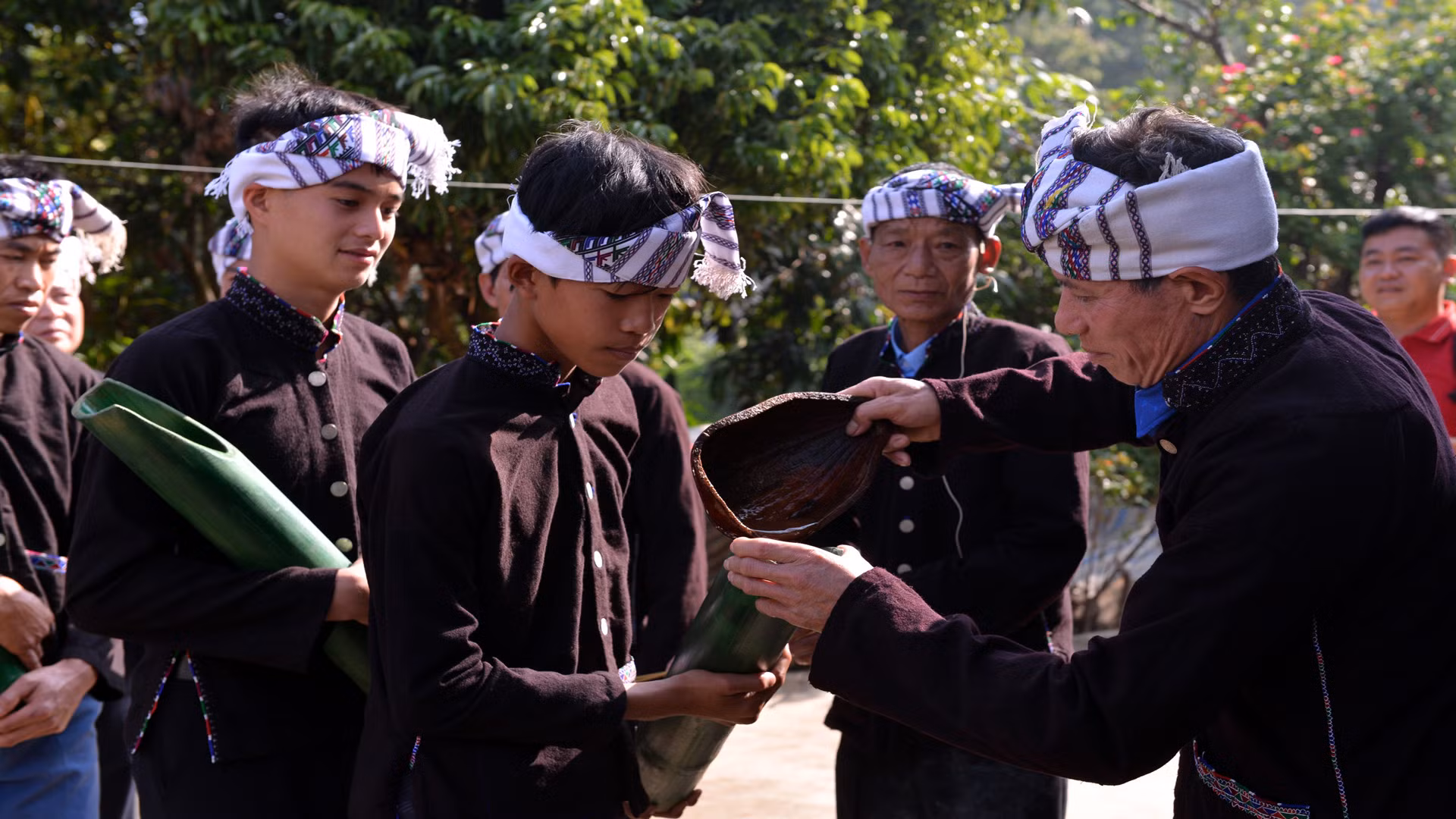 Lần lượt các nam thanh niên mang ống tre xin nước từ chủ nhà. Lần lượt các nam thanh niên mang ống tre xin nước từ chủ nhà.