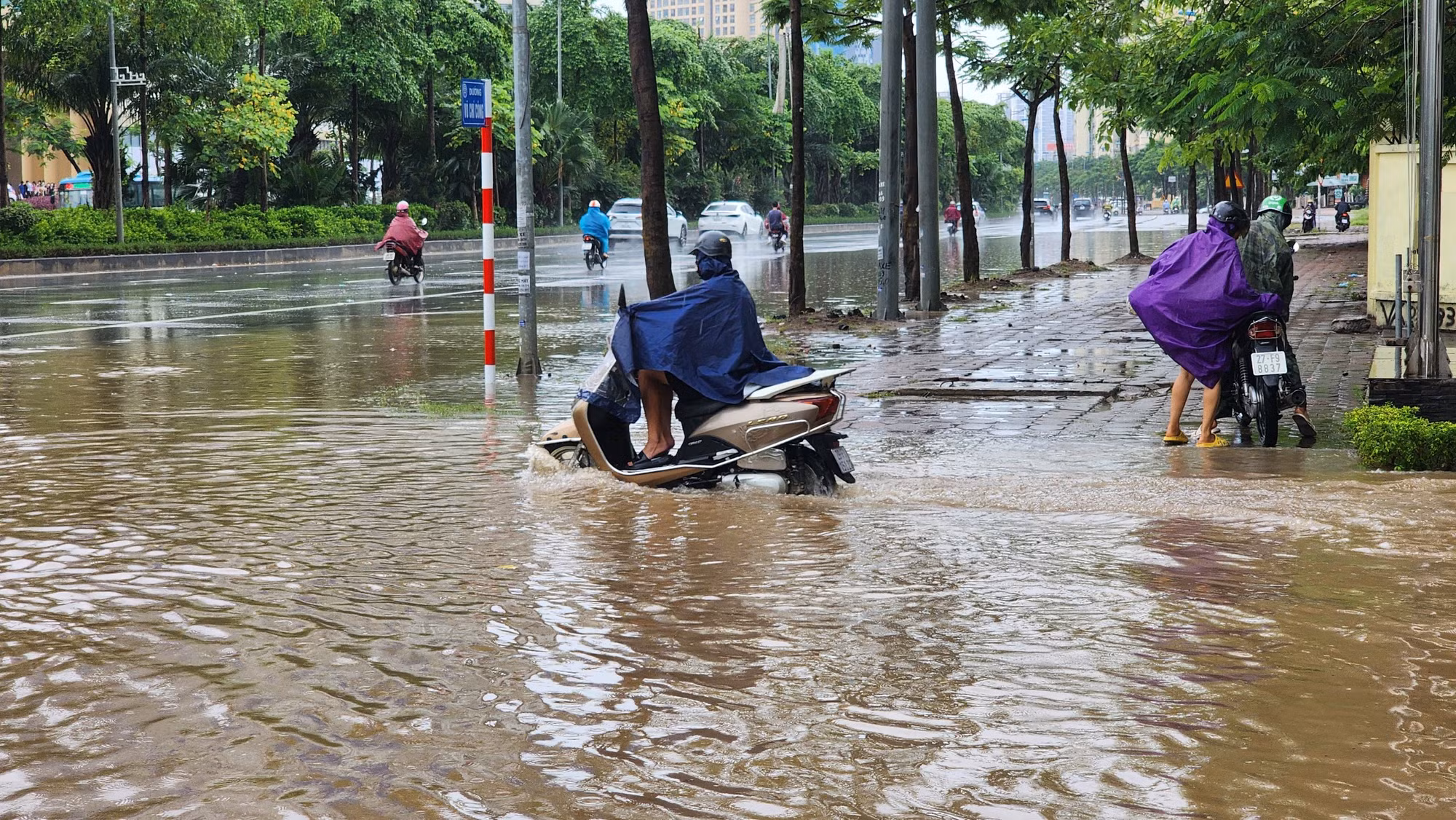 Nước ngập cao khiến việc di chuyển của xe máy gặp nhiều khó khăn.