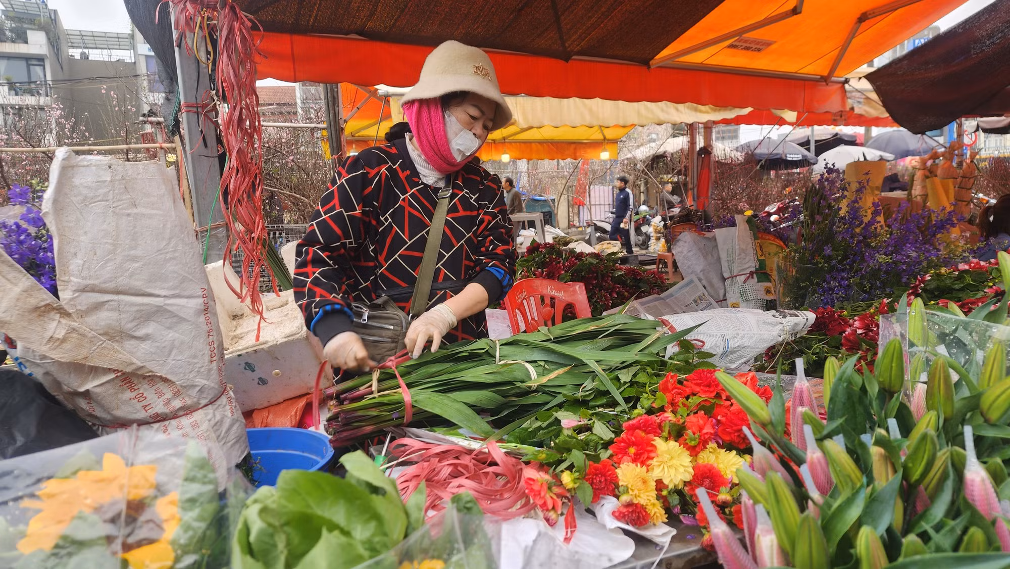 Chủ sạp hoa ly không ngưng tay vì lượng khách hỏi mua rất lớn. Đây là loại hoa người Hà Nội ưa thích cắm mỗi dịp Tết đến, xuân về.