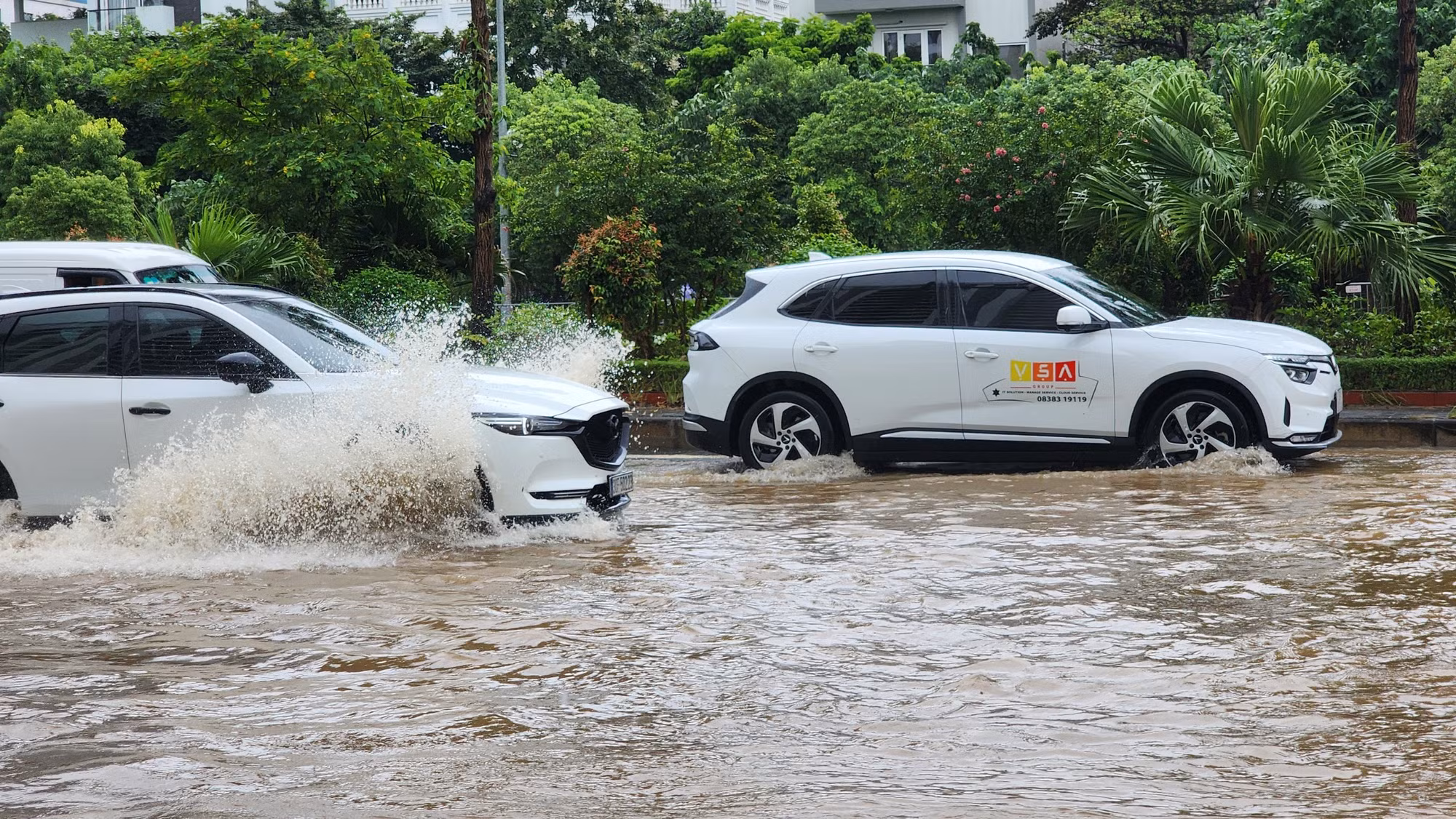 Nước ngập sâu 20-30cm khiến các phương tiện di chuyển khó khăn, một số xe bị chết máy.