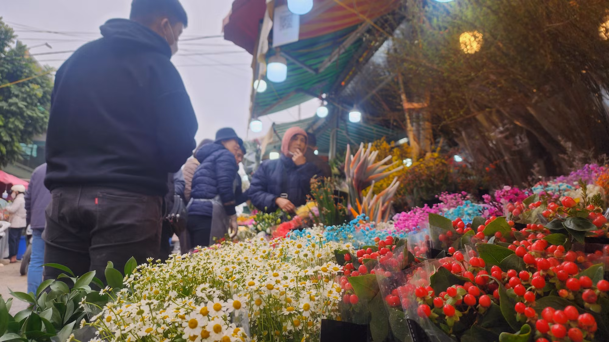 Hoa cúc, hoa đào đông chen nhau bên những gian hàng càng khiến cho không khí xuân trở nên rạo rực.