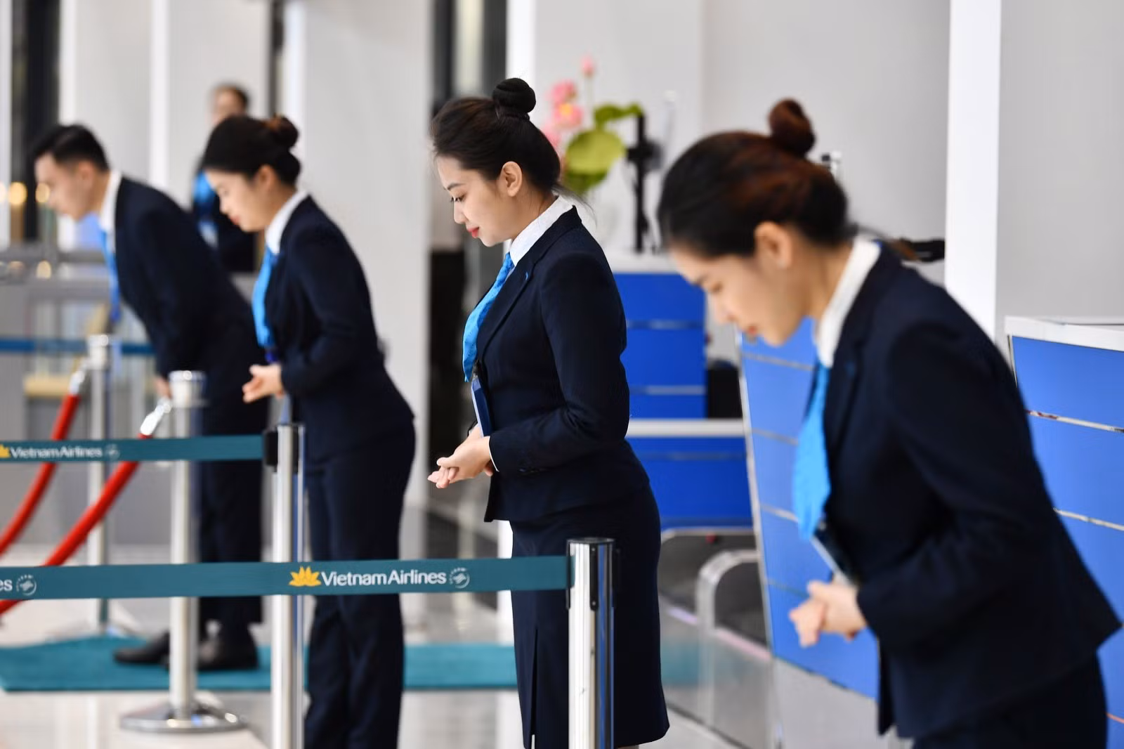 Nhân viên phục vụ mặt đất cúi chào hành khách để bắt đầu làm thủ tục chuyến bay Nhân viên phục vụ mặt đất cúi chào hành khách để bắt đầu làm thủ tục chuyến bay