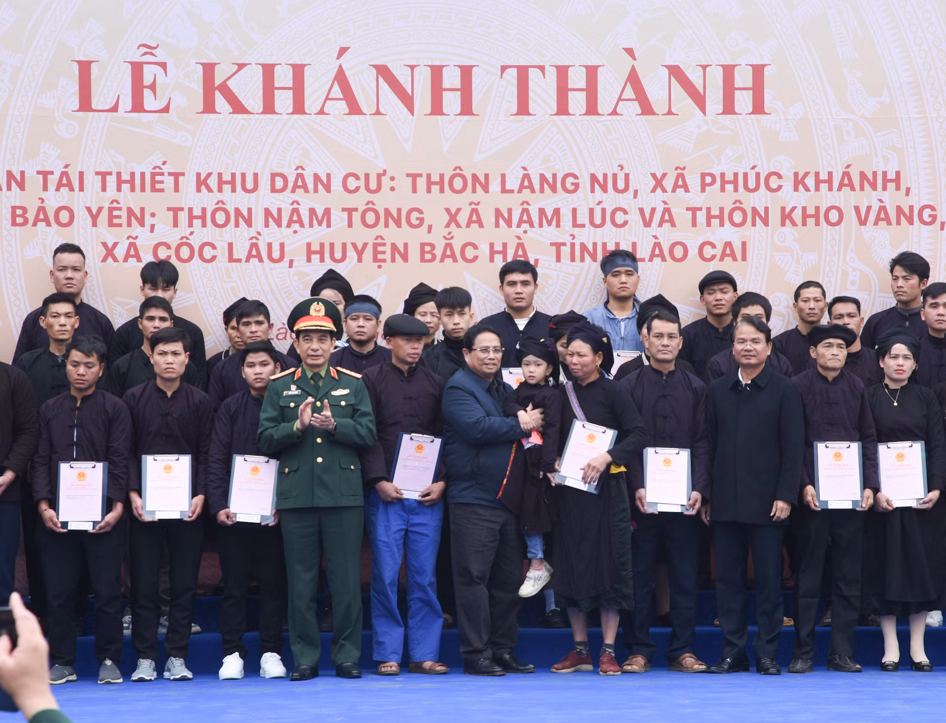 Thủ tướng Phạm Minh Chính và lãnh đạo địa phương trao chứng nhận quyền sử dụng đất tại nơi ở mới cho các gia đình thôn Làng Nủ.