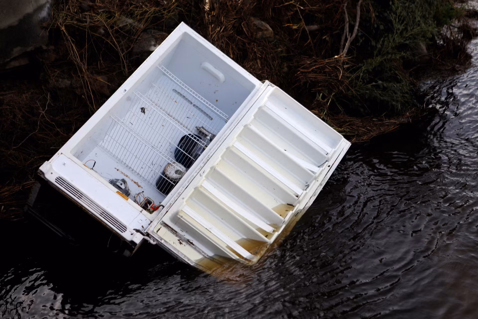 Một chiếc tủ lạnh mini trôi trên dòng nước lũ. (Ảnh: REUTERS)