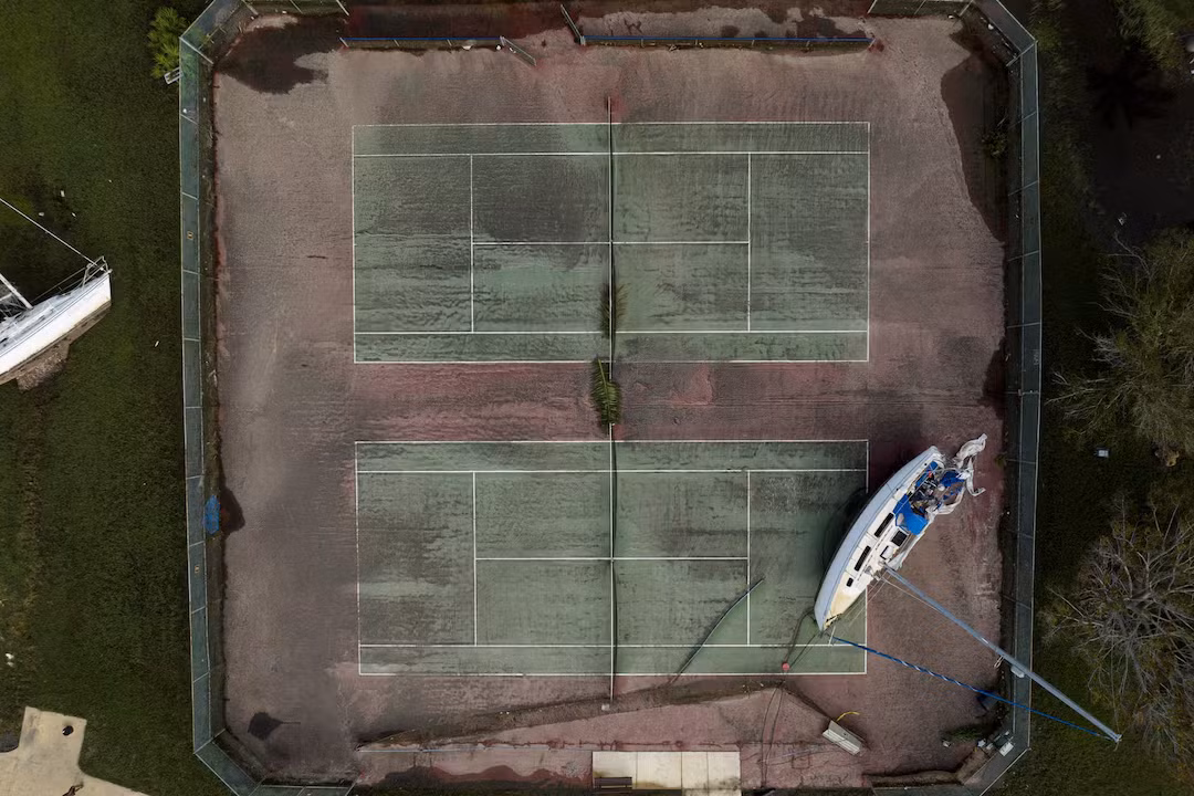 Trong ảnh là một chiếc du thuyền bị mắc kẹt trên sân tennis tại bang Florida sau bão Milton.