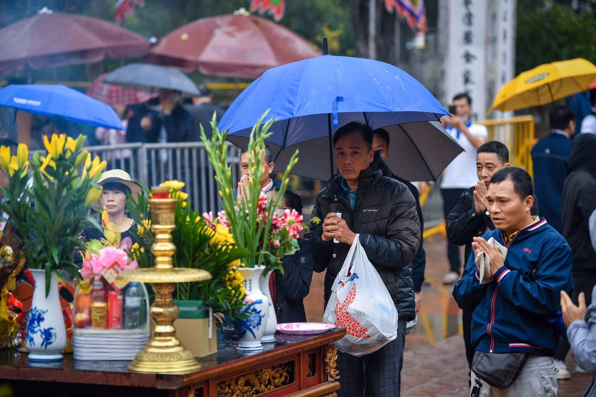 Du khách đội mưa làm lễ tại đền Trần trước giờ khai ấn. Du khách đội mưa làm lễ tại đền Trần trước giờ khai ấn.