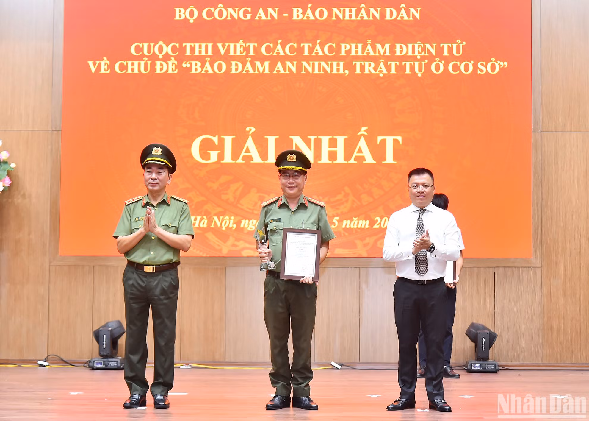 Các đồng chí Ủy viên Trung ương Đảng: Thượng tướng Trần Quốc Tỏ, Phó Bí thư Đảng ủy Công an Trung ương, Thứ trưởng điều hành hoạt động của Bộ Công an, Trưởng Ban Tổ chức cuộc thi; Lê Quốc Minh, Tổng Biên tập Báo Nhân Dân, Phó Trưởng Ban Tuyên giáo Trung ương, Chủ tịch Hội Nhà báo Việt Nam trao giải Nhất cho tác giả tại Lễ tổng kết. (Ảnh: THỦY NGUYÊN)