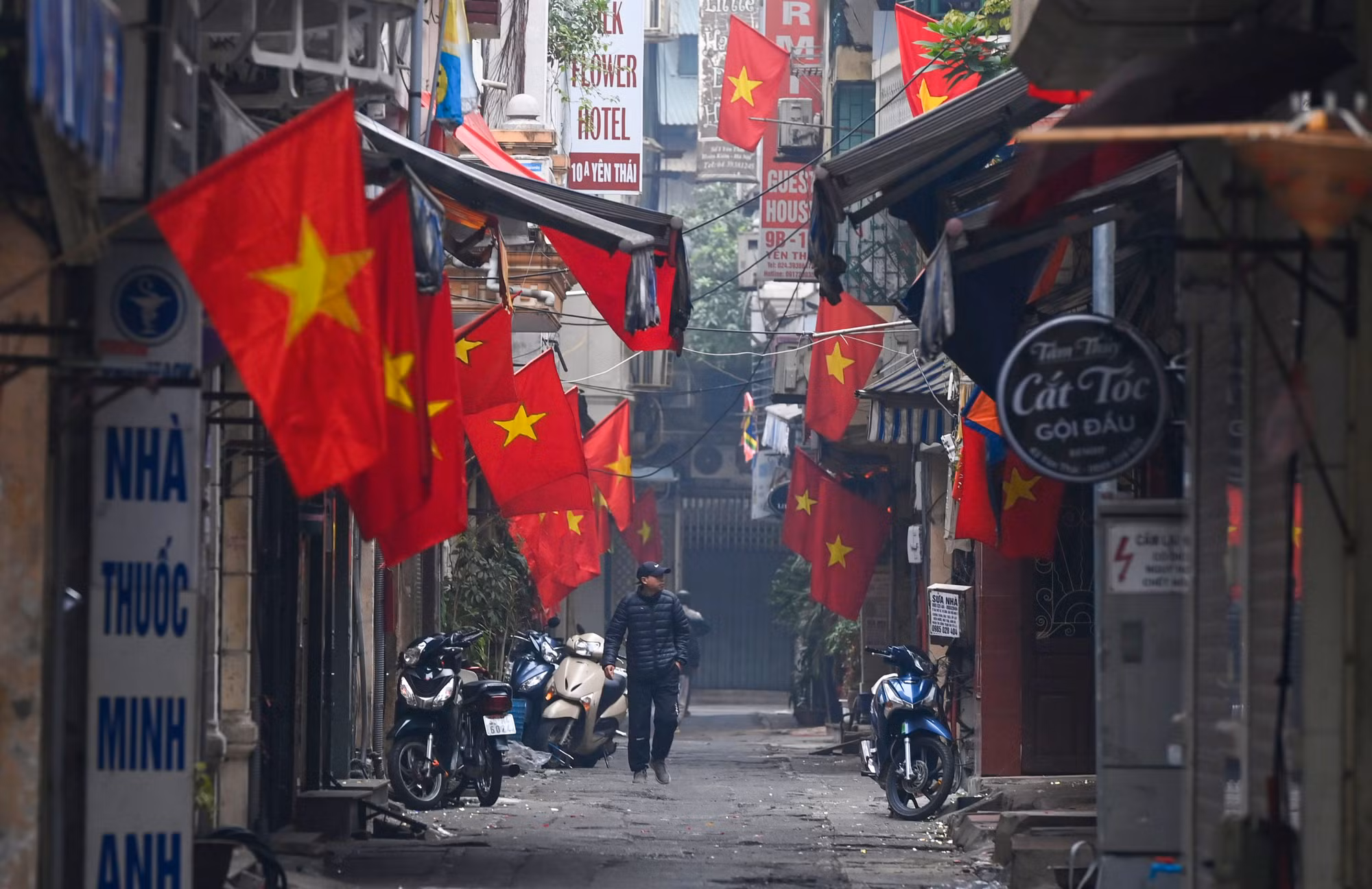 Những con phố nhỏ rực rỡ cờ hoa lác đác vài bóng người đi chúc Tết sớm trong sáng mùng Một Tết. (Ảnh: THÀNH ĐẠT)