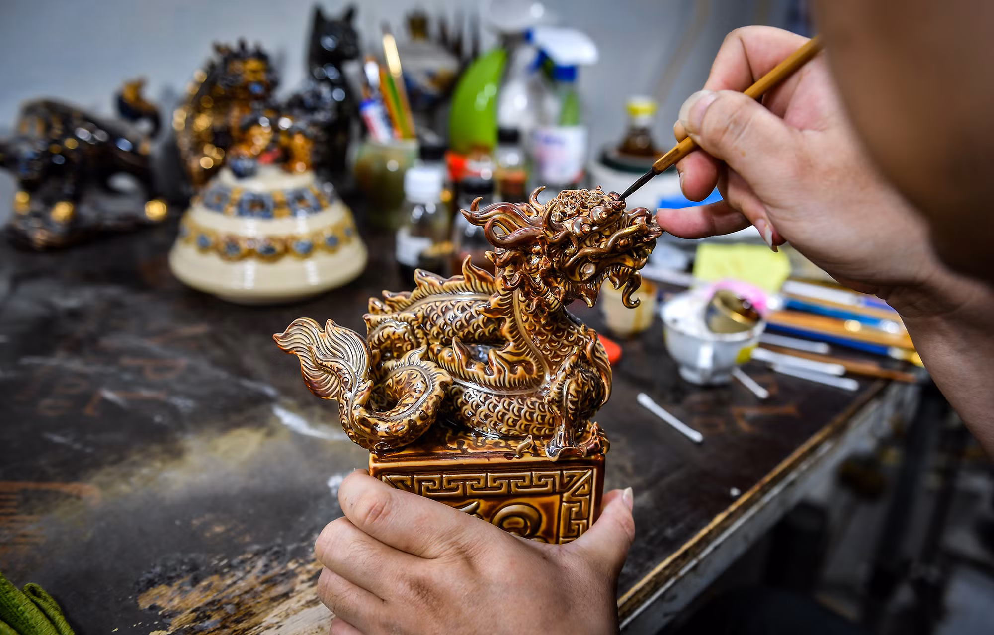 Người thợ thủ công chăm chú trong từng chi tiết để bảo đảm sản phẩm được hoàn thiện một cách sắc nét nhất. Người thợ thủ công chăm chú trong từng chi tiết để bảo đảm sản phẩm được hoàn thiện một cách sắc nét nhất.