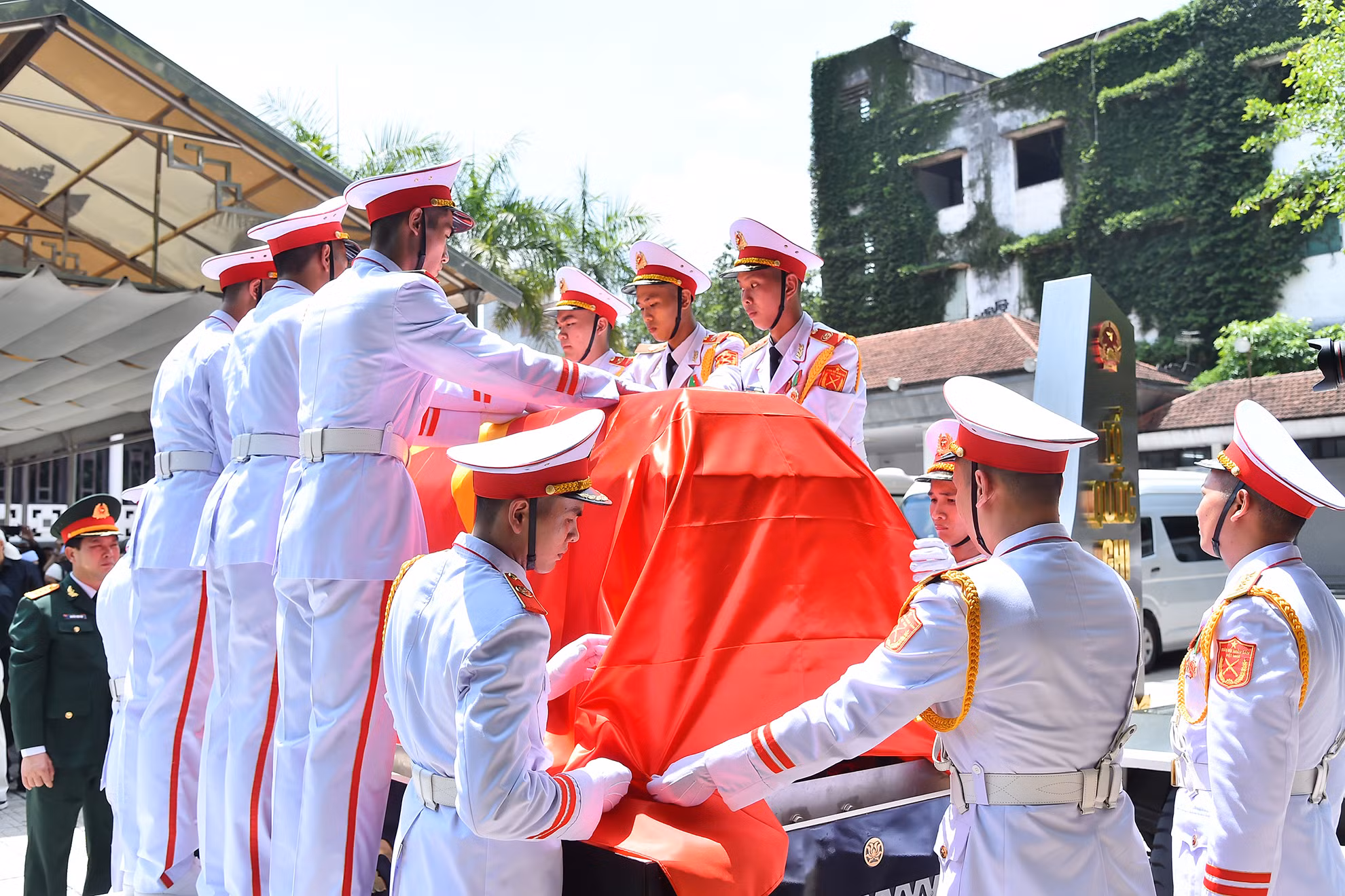 Đoàn nghi lễ quân đội phủ lá cờ Tổ quốc lên linh cữu đồng chí Nguyễn Khánh.