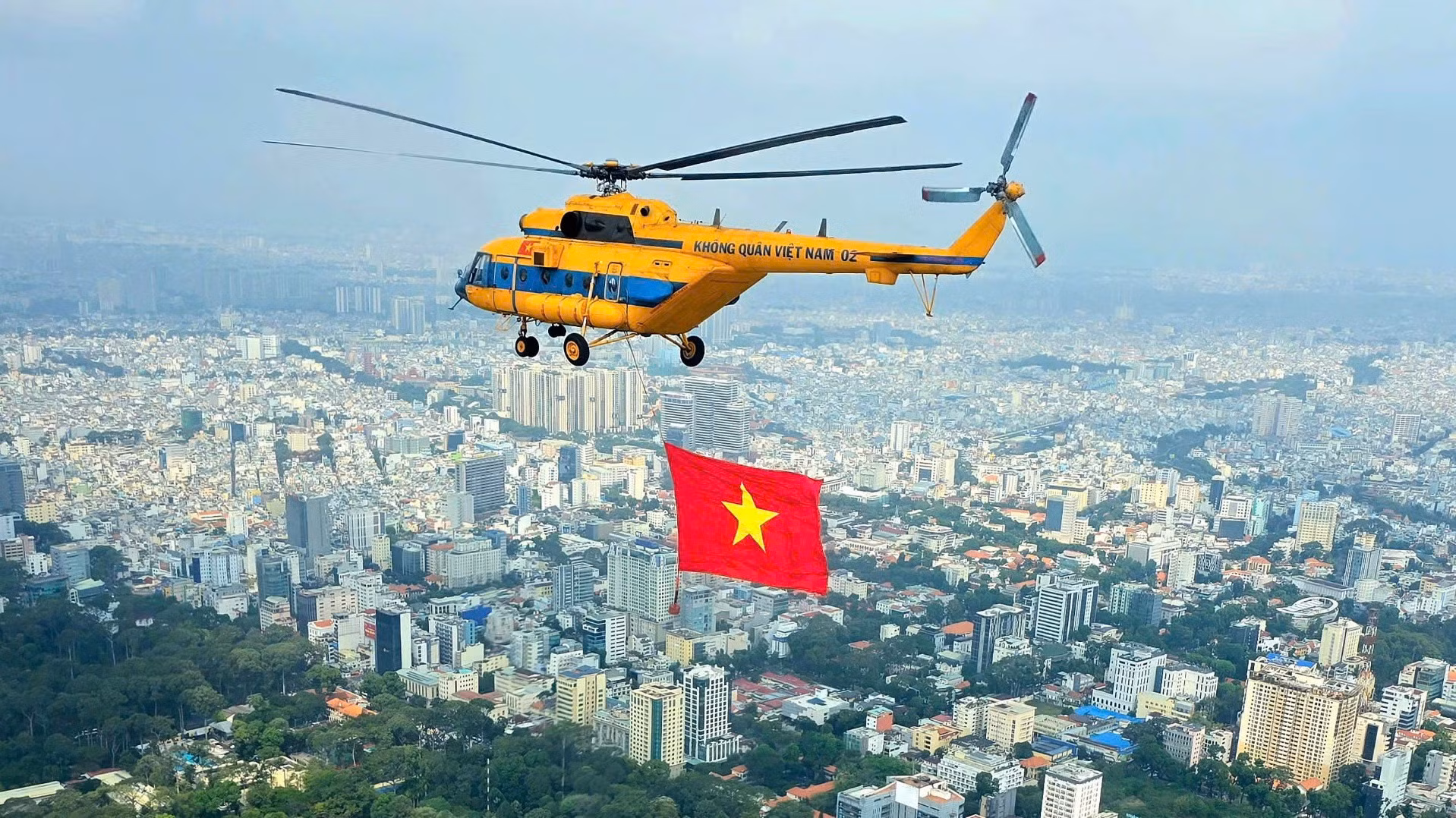 Máy bay trực thăng kéo cờ Tổ quốc luyện tập trên bầu trời Thành phố Hồ Chí Minh.
