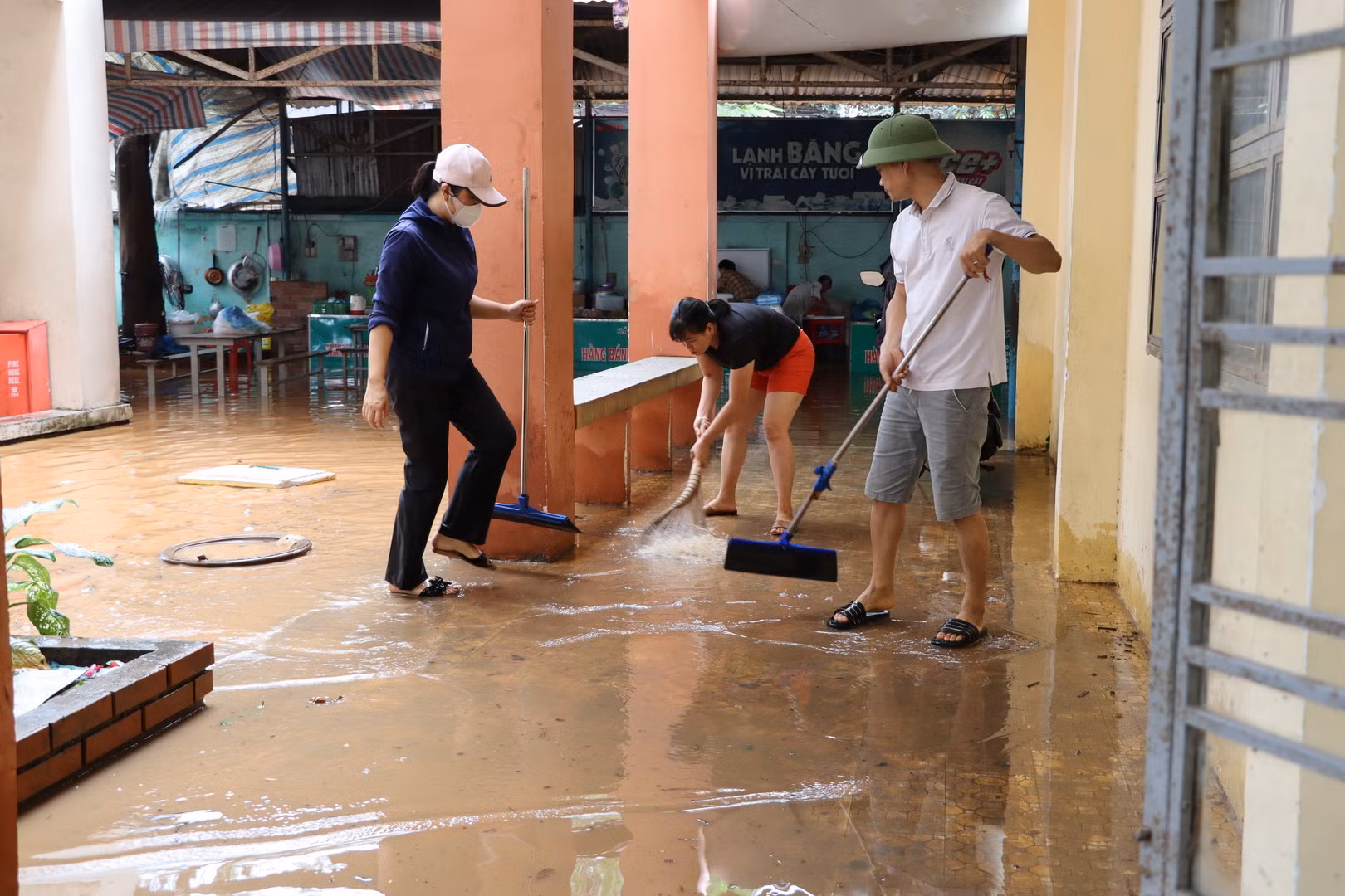 Các thầy cô giáo Trường trung học cơ sở Phước Tân 1 tiến hành dọn dẹp khi nước lũ rút dần.